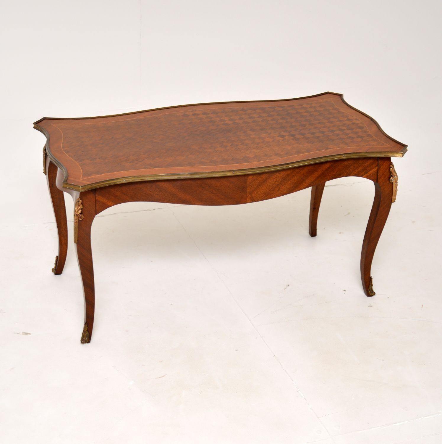 A very beautiful and elegant antique French coffee table, this dates from around the 1930’s.

It is of superb quality, with gorgeous parquetry inlay on the top and a solid wood frame. There are high quality ormolu mounts on the edges, knees and