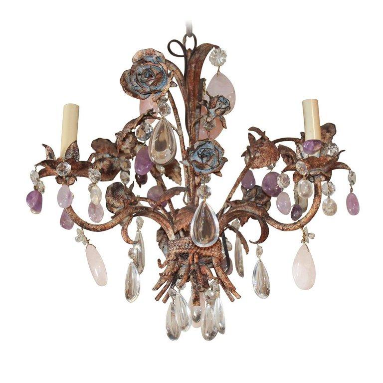 Antique French iron and crystal chandelier adorned with amethyst, rose quartz and clear glass drops. The chandelier is enhanced with large patinated iron rosettes.  It comes with matching chain and a canopy ready to hang.

circa 1910.