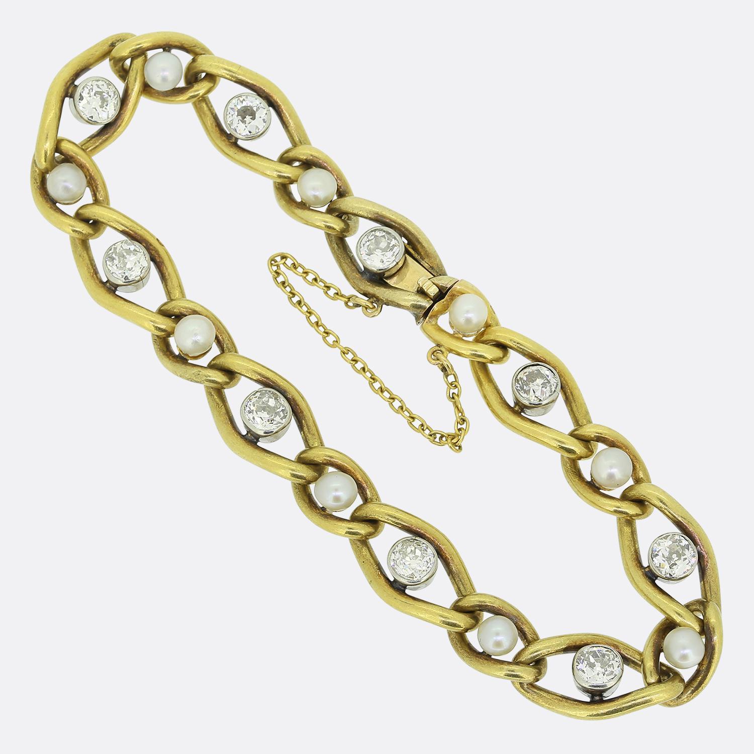 Here we have a fabulous chain link bracelet taken from the Victorian period. This antique piece features an alternating array of round natural white pearls and round faceted old mine cut diamonds. Each stone is set within an open oval shaped link