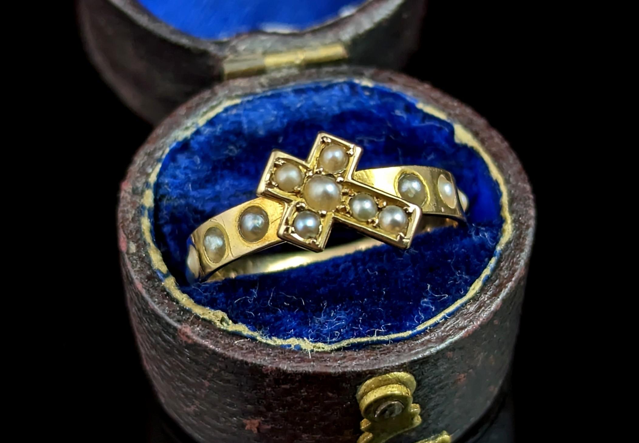 This rare antique French pearl cross ring is really quite a magnificent piece.

It is crafted from 18kt yellow gold with a straight band in an almost eternity style with seed pearls adorning the band almost all the way round.

The front of the band