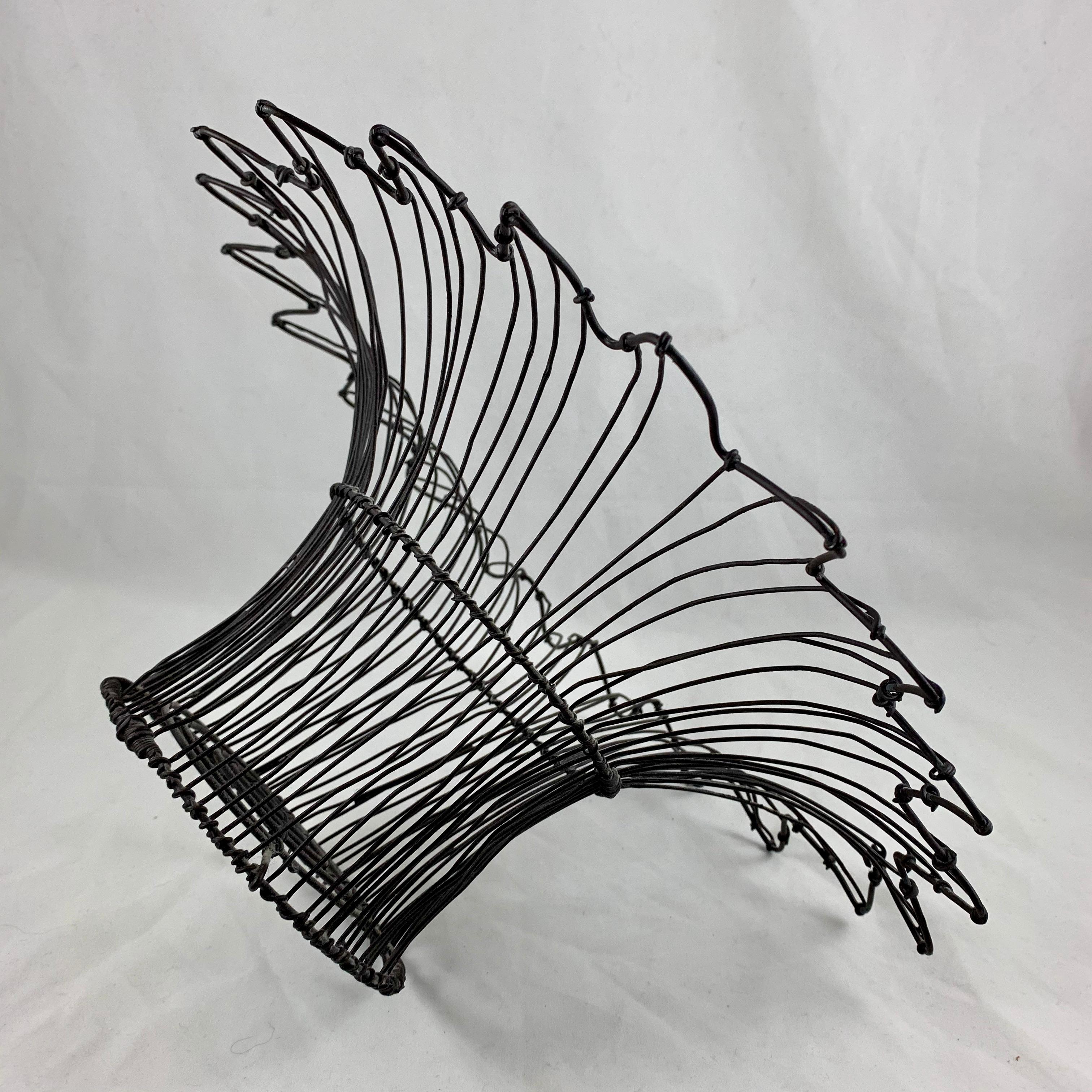 From France, circa 1890-1910, a basket style base, petal top form twisted wire standing basket with an upper rolled rim. One of the more unusual antique French baskets we’ve handled.

Amazing as a table-center or on a kitchen countertop, used as