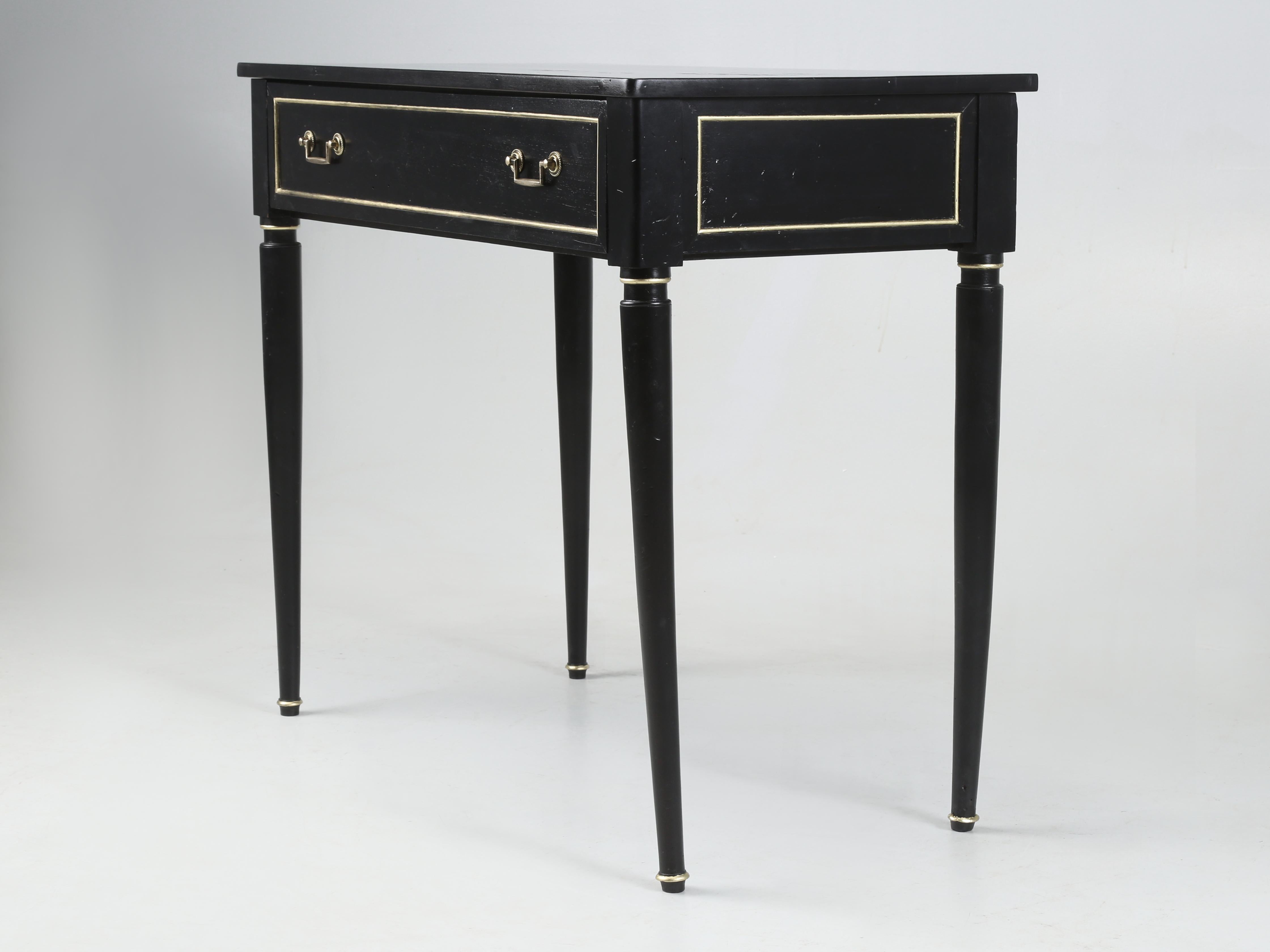Antique French Petite Louis XVI Style Console Table o potrebbe essere un Ladies Writing Table con un ampio cassetto in finitura ebanizzata. Il tavolo è piuttosto vecchio e le gambe hanno una forma un po' a gatto, ma è strutturalmente solido, così