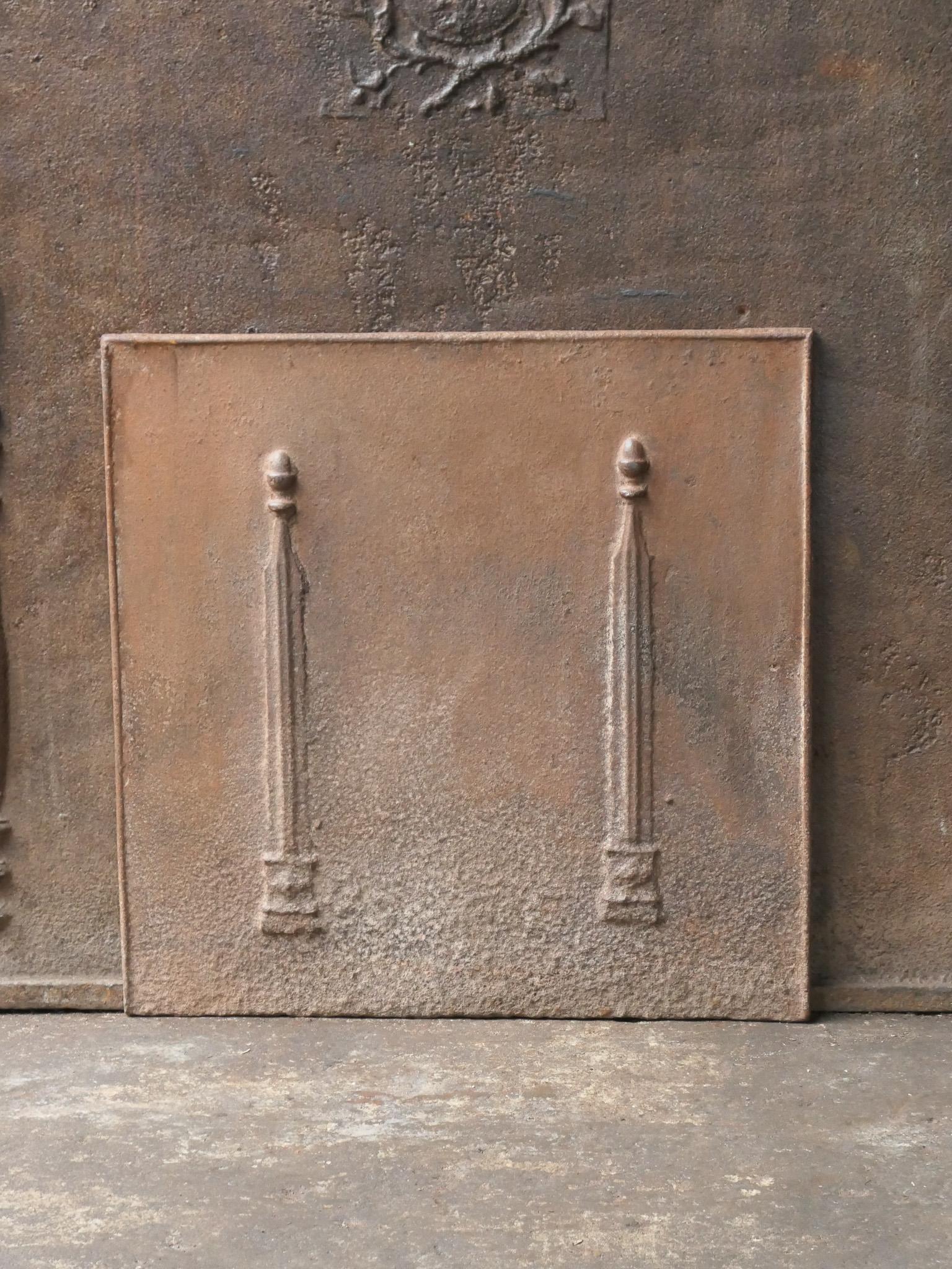 18th - 19th century French neoclassical fireback with two pillars of freedom. The pillars symbolize the value liberty, one of the three values of the French revolution. 

The fireback is made of cast iron and has a natural brown patina. Upon request