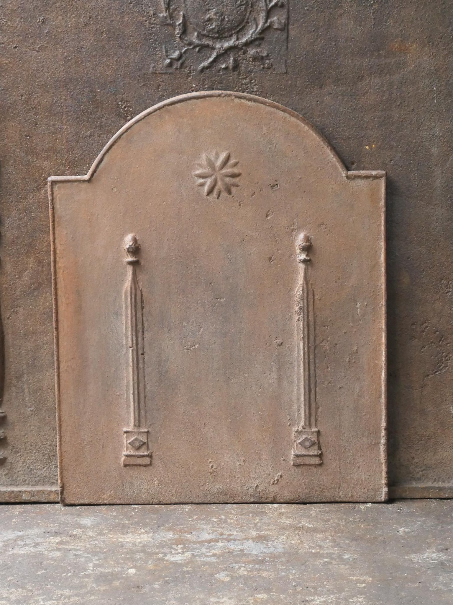 Plaque de cheminée néoclassique française du 18e - 19e siècle avec deux piliers de la liberté. Les piliers symbolisent la valeur liberté, l'une des trois valeurs de la Révolution française. 

La plaque de cheminée est en fonte et a une patine brune