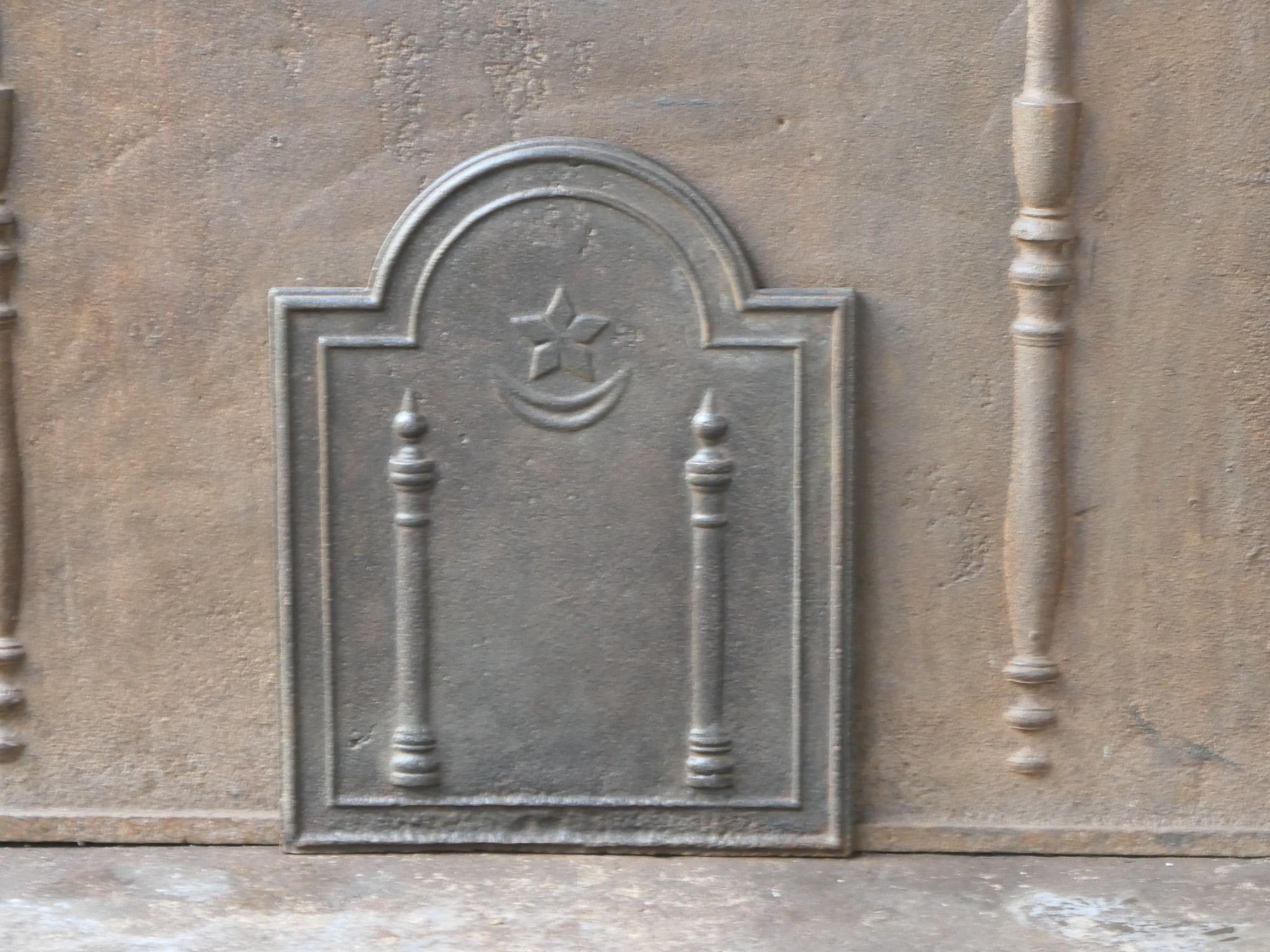 Plaque de cheminée néoclassique française du 18e - 19e siècle avec deux piliers de la liberté. Les piliers symbolisent la valeur liberté, l'une des trois valeurs de la Révolution française. 

La plaque de cheminée est en fonte et a une patine brune