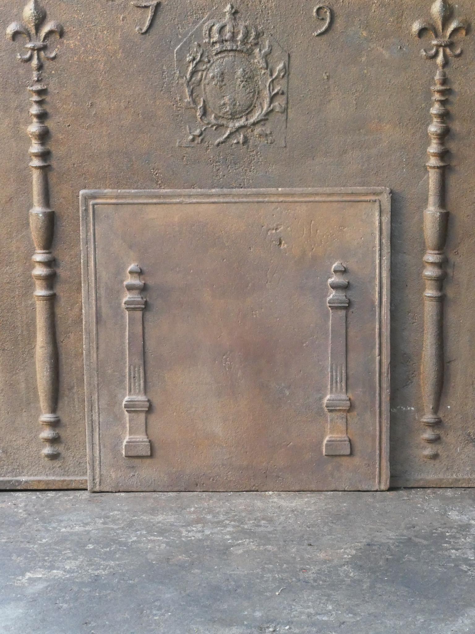 18th - 19th century French neoclassical fireback with two pillars of freedom. The pillars symbolize the value liberty, one of the three values of the French revolution. 

The fireback is made of cast iron and has a natural brown patina. Upon request