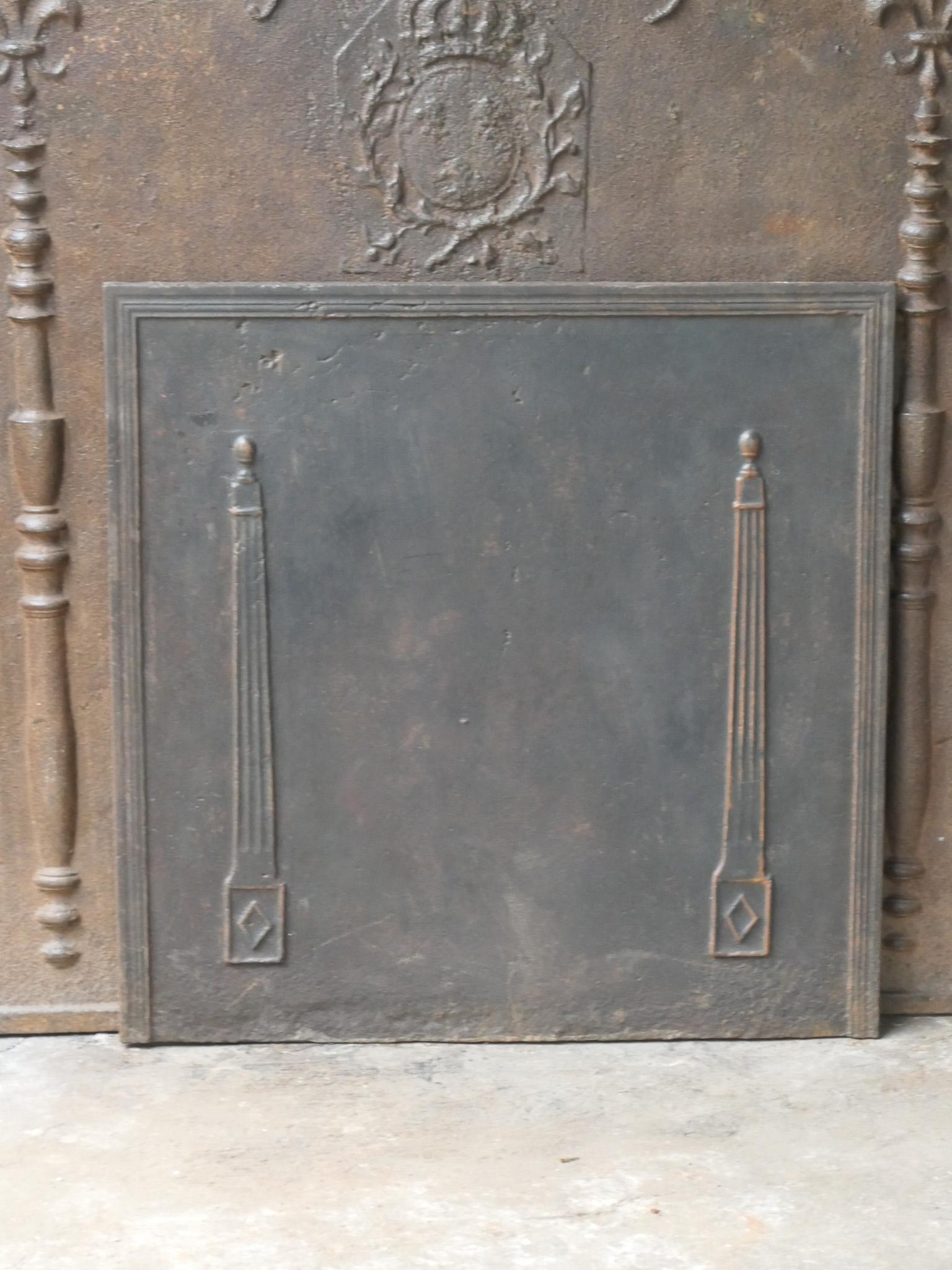 18th - 19th century French neoclassical fireback with two pillars of freedom. The pillars symbolize the value liberty, one of the three values of the French revolution. 

The fireback is made of cast iron and has a natural brown patina. Upon request