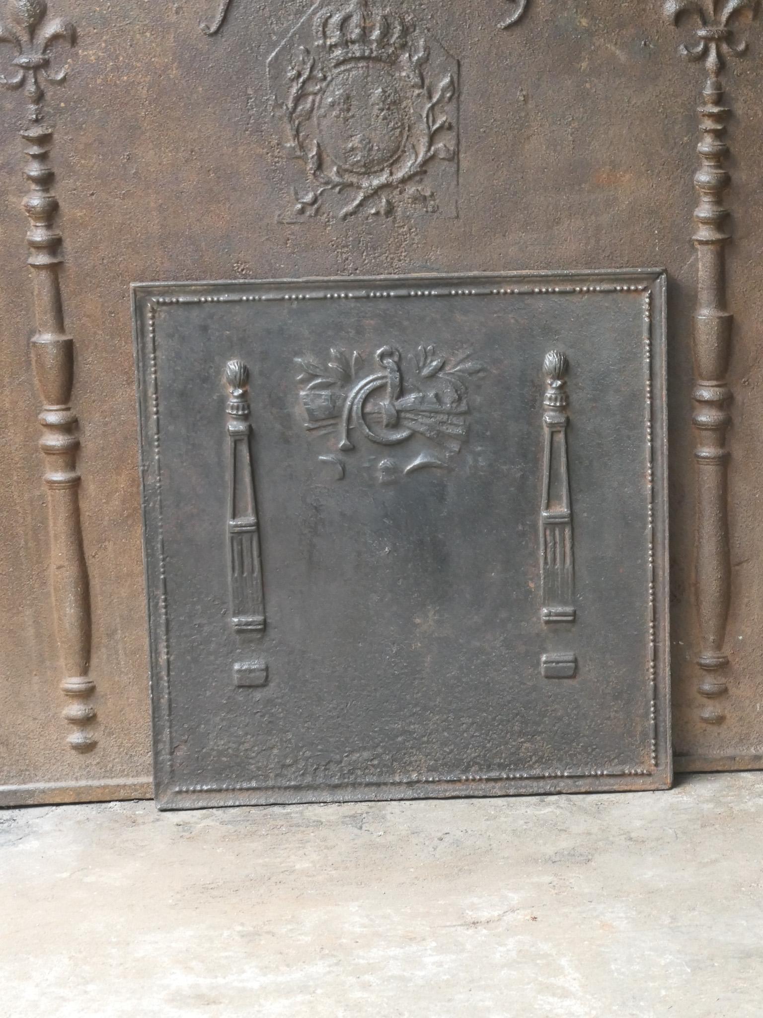 18th - 19th century French neoclassical fireback with two pillars of freedom. The pillars symbolize the value liberty, one of the three values of the French revolution. 

The fireback is made of cast iron and has a natural brown patina. Upon request