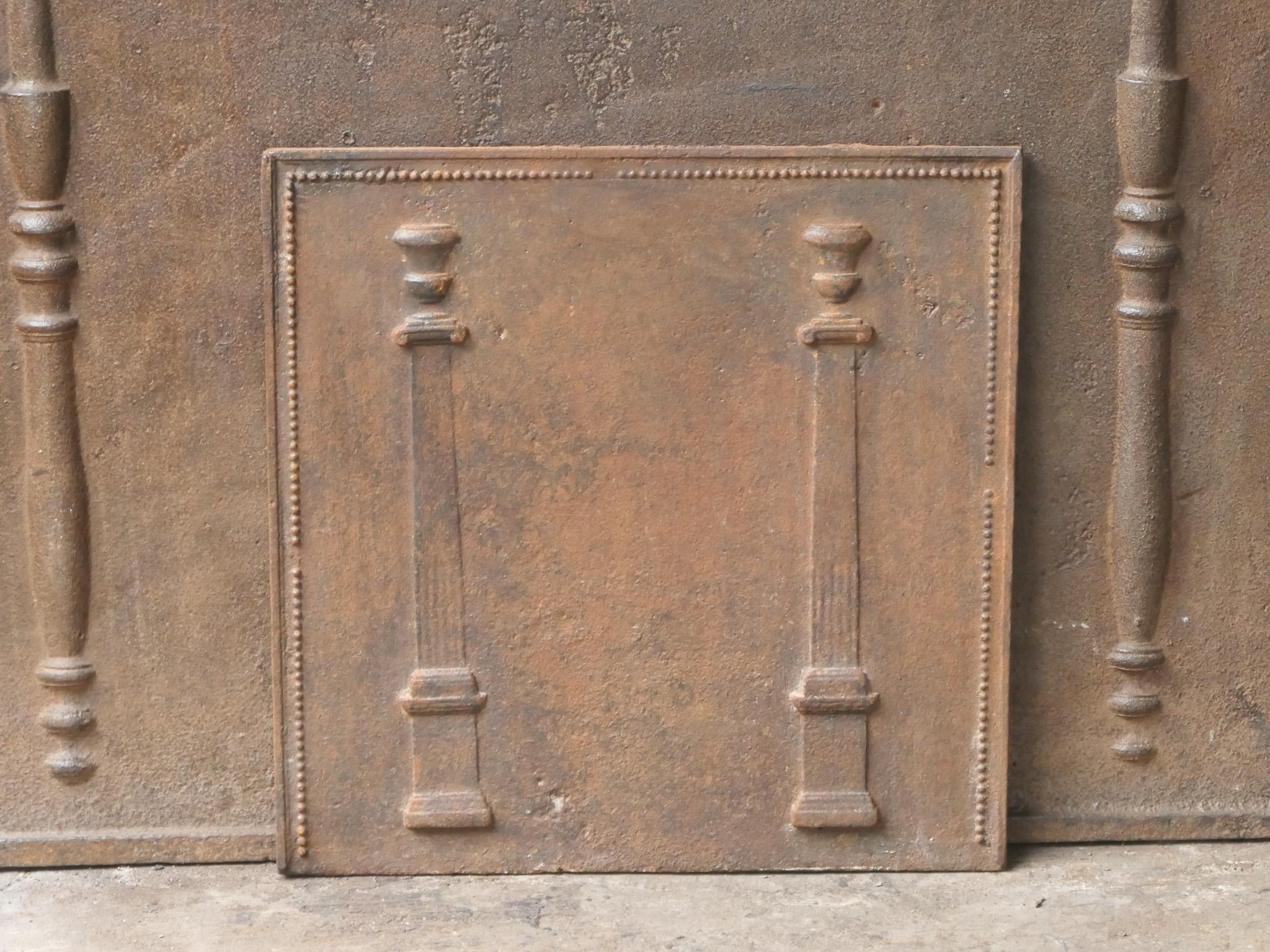 18th - 19th century French neoclassical fireback with two pillars of freedom. The pillars symbolize the value liberty, one of the three values of the French revolution. 

The fireback is made of cast iron and has a natural brown patina. Upon request