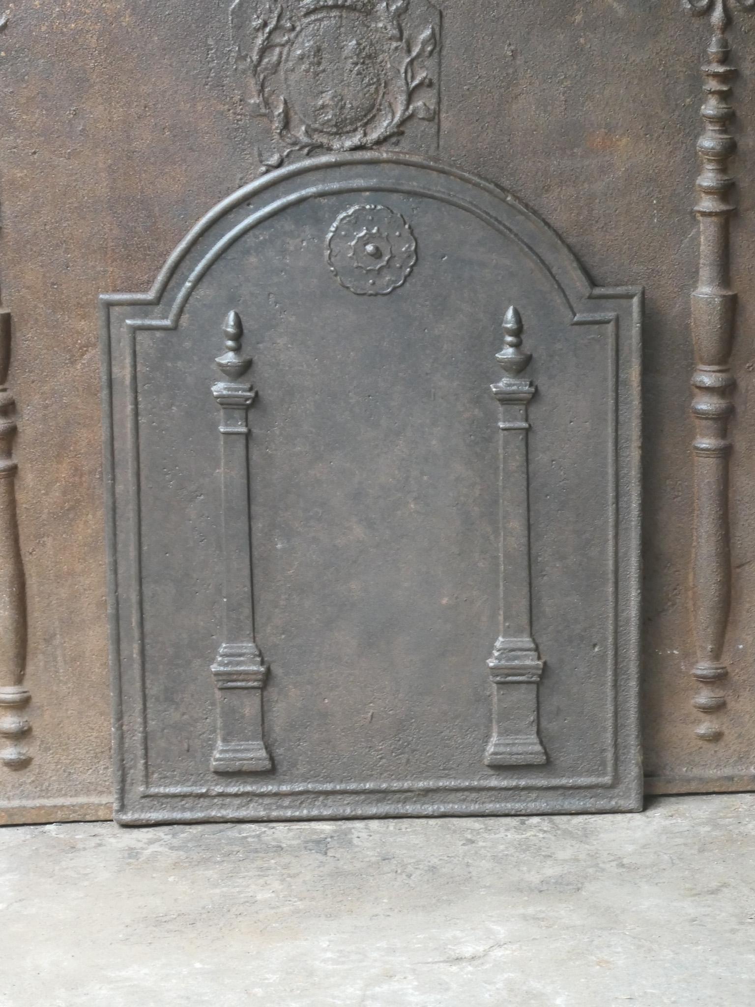18th - 19th century French neoclassical fireback with two pillars of freedom. The pillars symbolize the value liberty, one of the three values of the French revolution. 

The fireback is made of cast iron and has a natural brown patina. Upon request