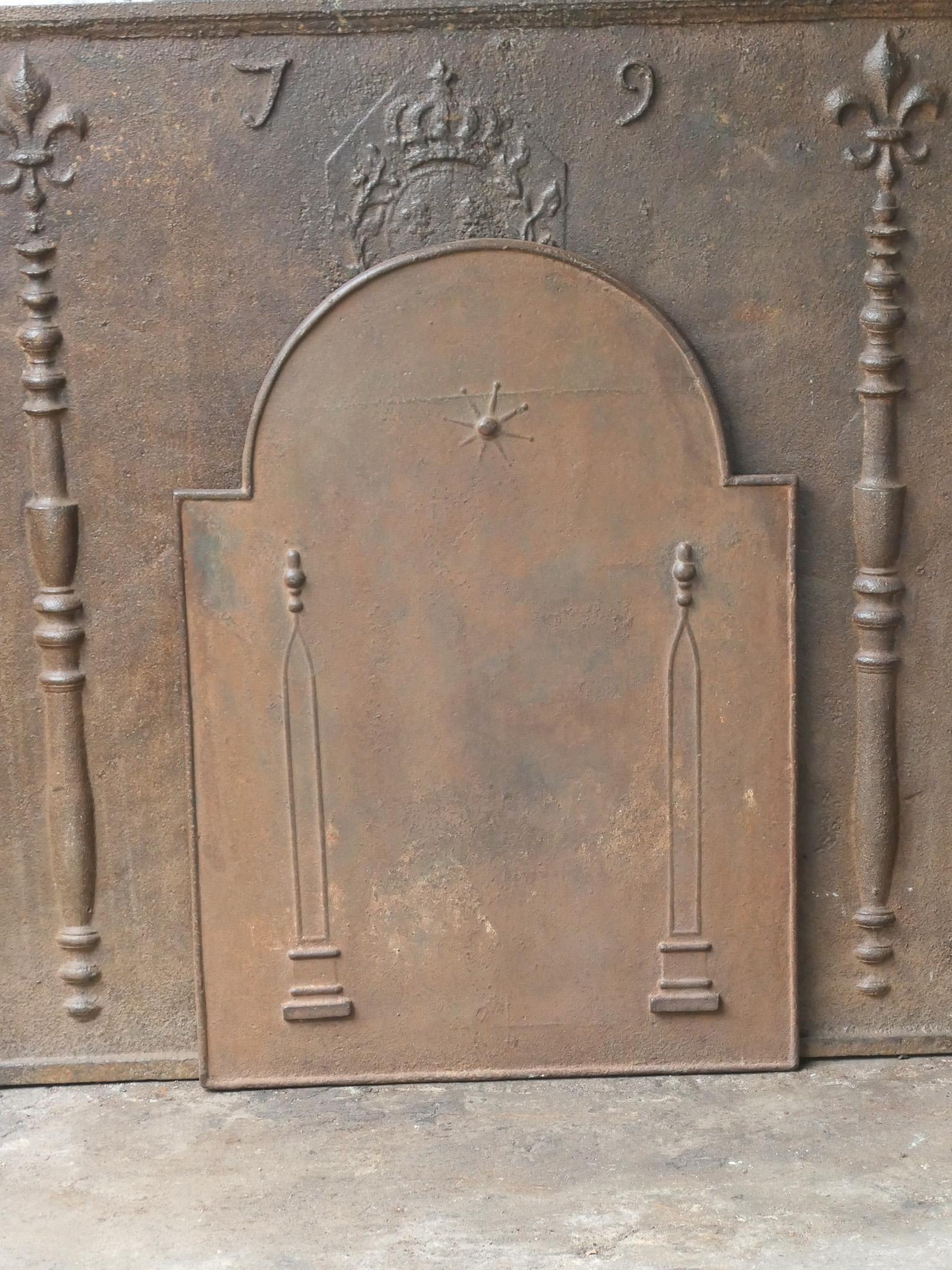 18th - 19th century French neoclassical fireback with two pillars of freedom. The pillars symbolize the value liberty, one of the three values of the French revolution. 

The fireback is made of cast iron and has a natural brown patina. Upon request