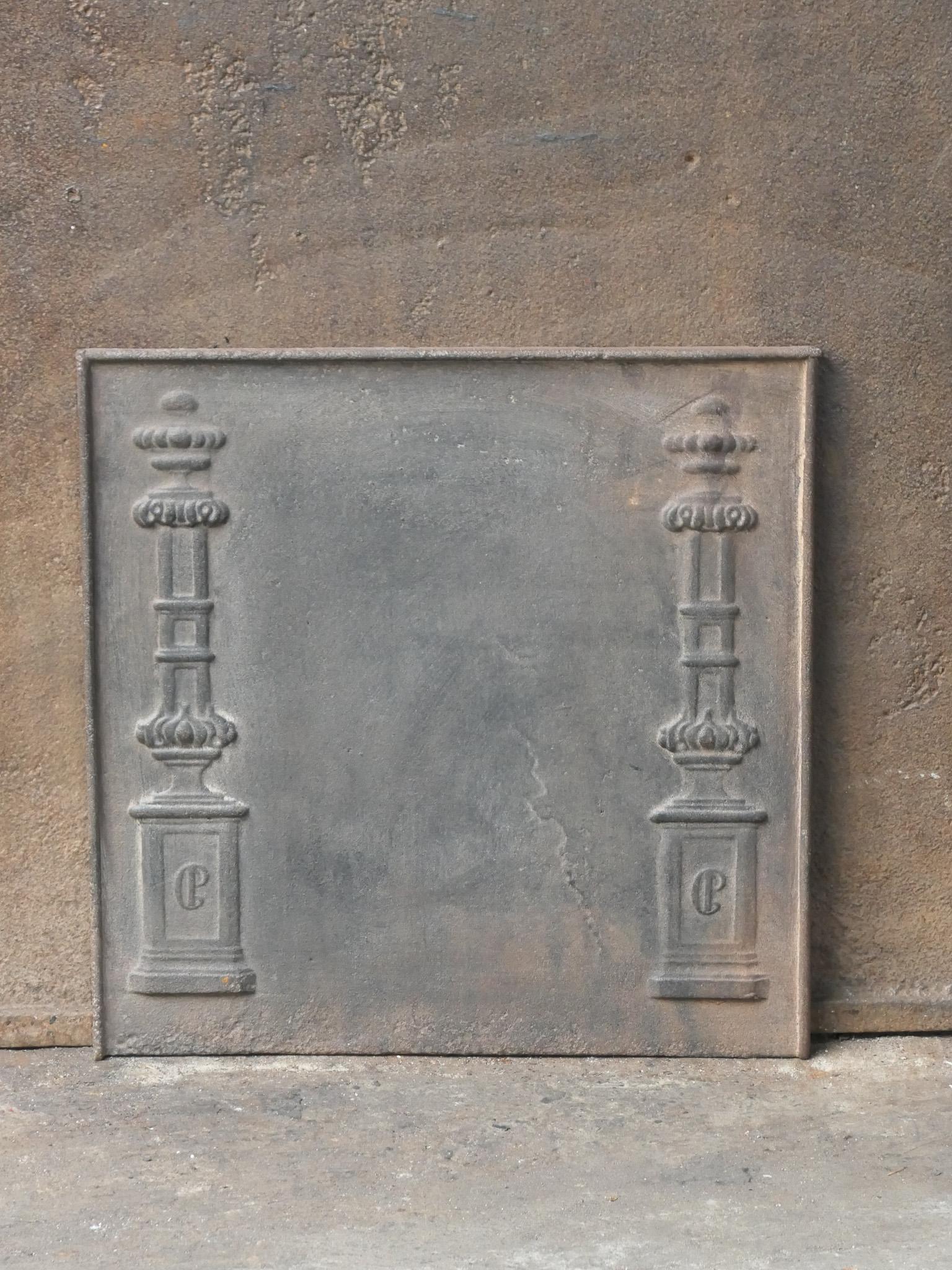 18th - 19th century French neoclassical fireback with two pillars of freedom. The pillars symbolize the value liberty, one of the three values of the French revolution. 

The fireback is made of cast iron and has a natural brown patina. Upon request