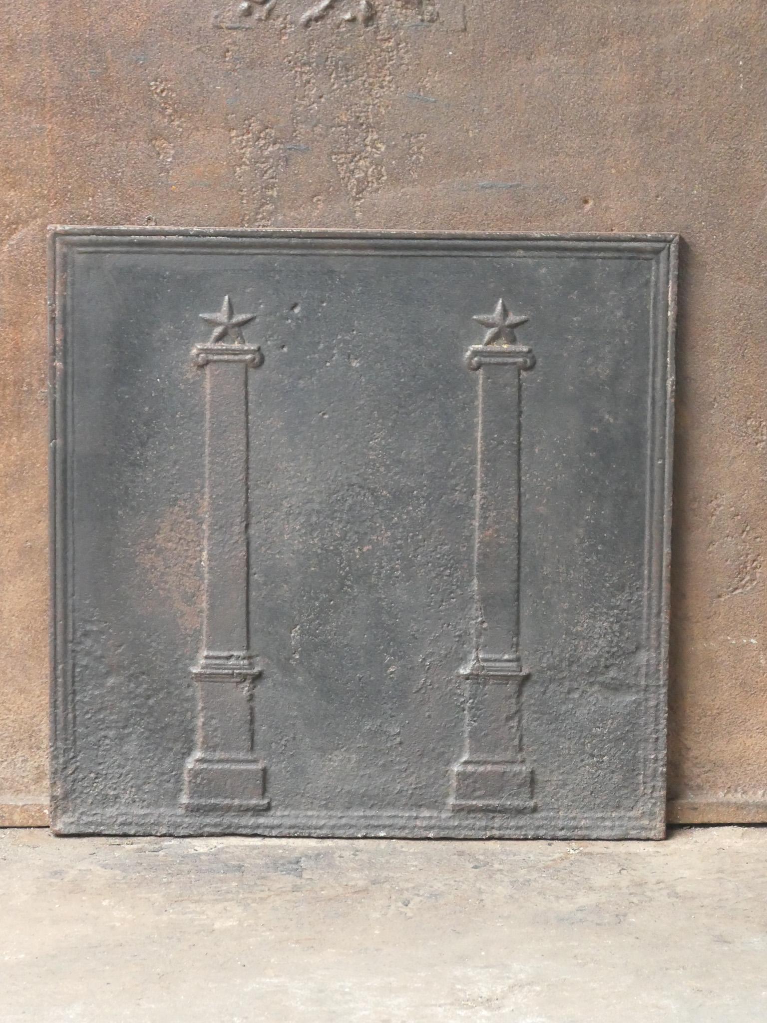 18th - 19th century French neoclassical fireback with two pillars of freedom. The pillars symbolize the value liberty, one of the three values of the French revolution. 

The fireback is made of cast iron and has a natural brown patina. Upon request