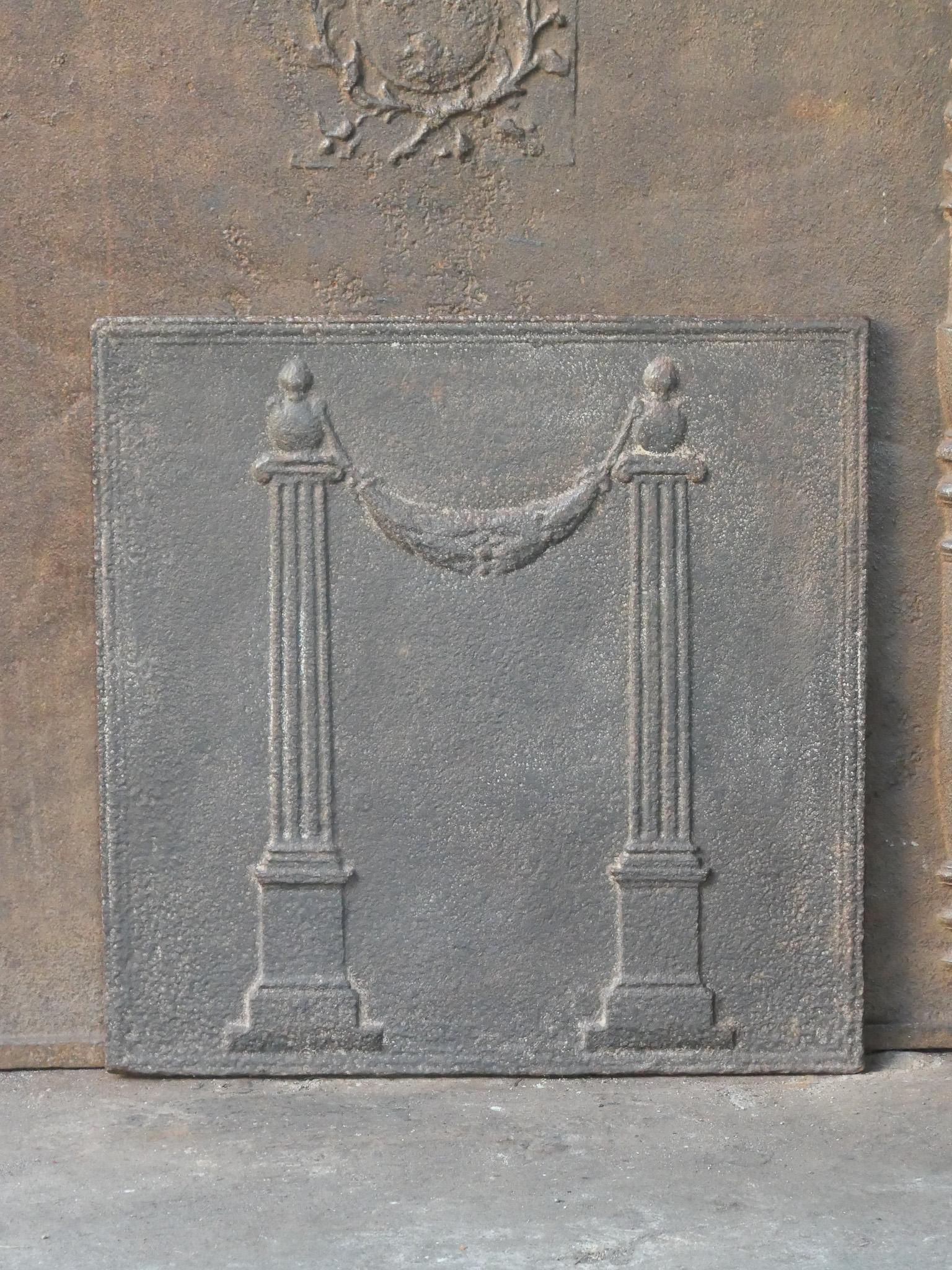 18th - 19th century French neoclassical fireback with two pillars of freedom. The pillars symbolize the value liberty, one of the three values of the French revolution. 

The fireback is made of cast iron and has a natural brown patina. Upon request