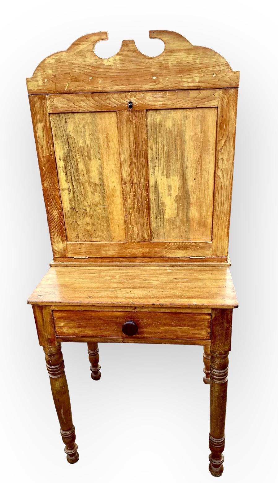 A primitive, charming antique French Louis Philippe pine and walnut drop-lid farm desk with fitted interior,  three hand dovetailed drawers and compartments, the drop lid with lock and key. The cabinet top beautifully dovetailed together and having