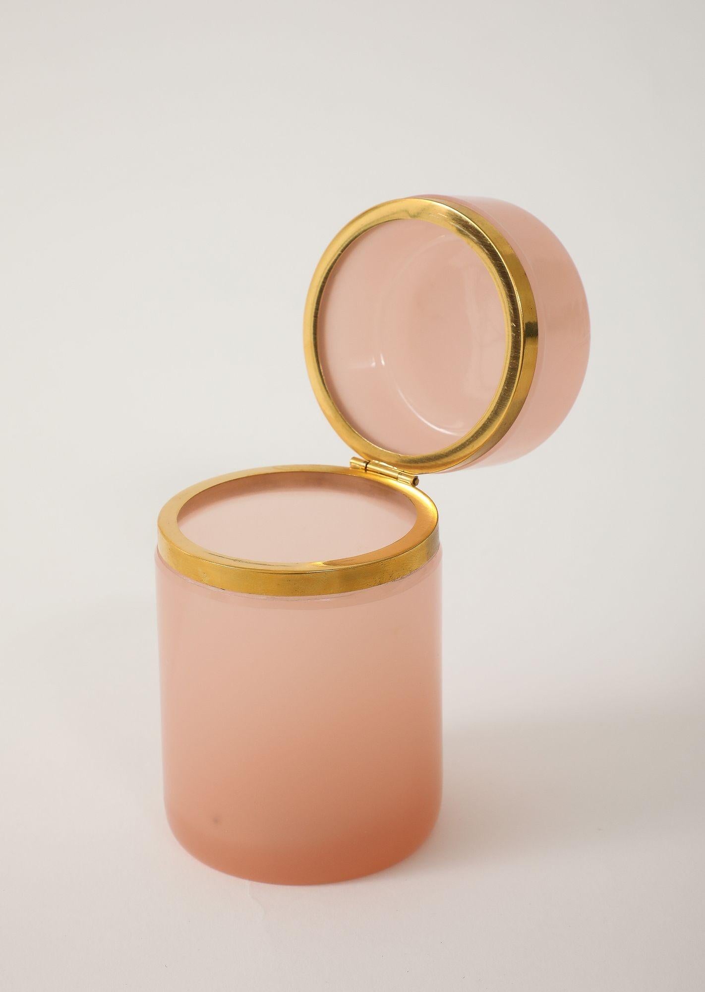 Rare boîte cylindrique en verre opalin de couleur rose pâle, datant du début du 20e siècle en France. Cette pièce remarquable présente des montures en laiton d'origine et un couvercle à charnière, qui mettent en valeur le raffinement de l'artisanat.