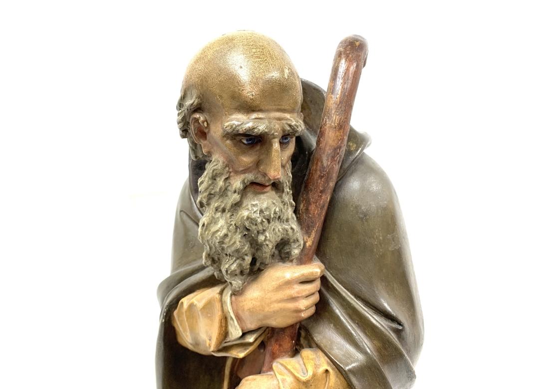 Statue ancienne en plâtre d'un personnage religieux, probablement un berger ou un saint, provenant peut-être d'une scène de la Nativité, fin 19e, début 20e siècle.  Le personnage, aux yeux de verre, tient un bâton et porte une robe, comme dans les