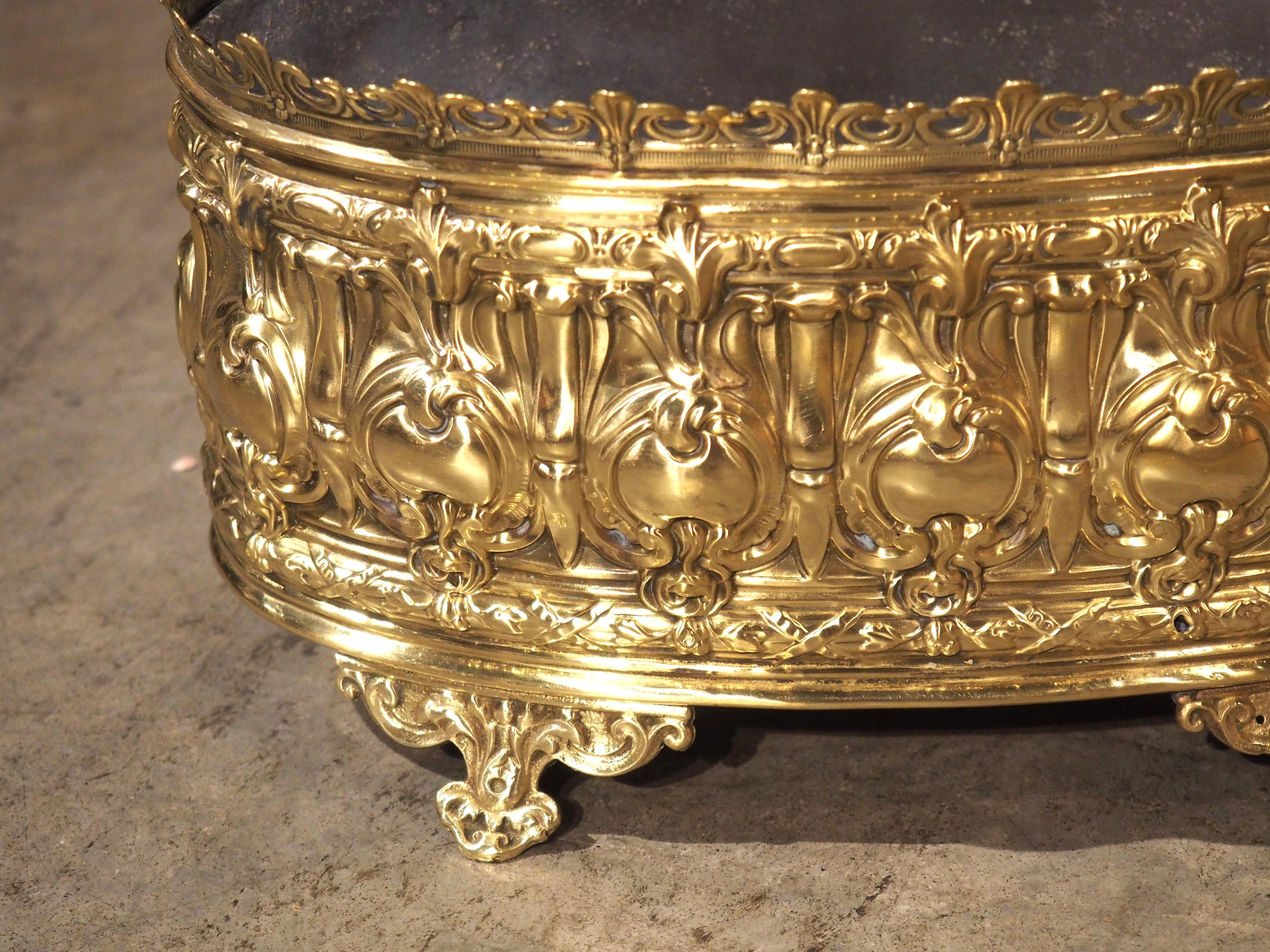 This beautiful, polished brass jardiniere from France has been hand-worked in a technique known as repoussé, where decorative motifs are hammered from the inside, forming low-relief imagery. Dating to circa 1900, the main body has a vibrant golden