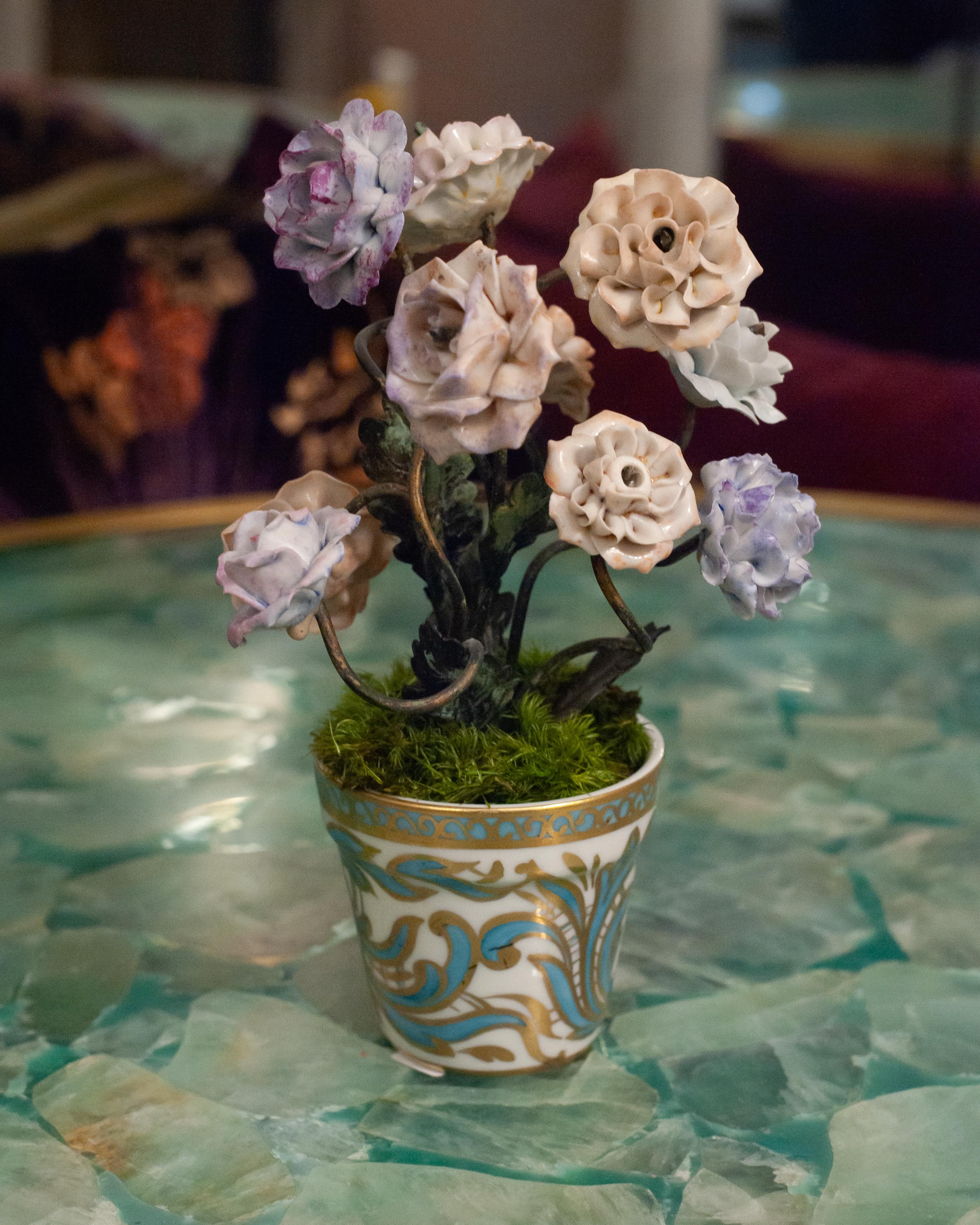 Uno studio di porcellana e poesia - Questa antica composizione francese cattura la bellezza fugace della natura in una forma duratura. Fiori di porcellana lavorati a mano, smaltati in rosa tenue e lavanda, poggiano su delicati steli e foglie di