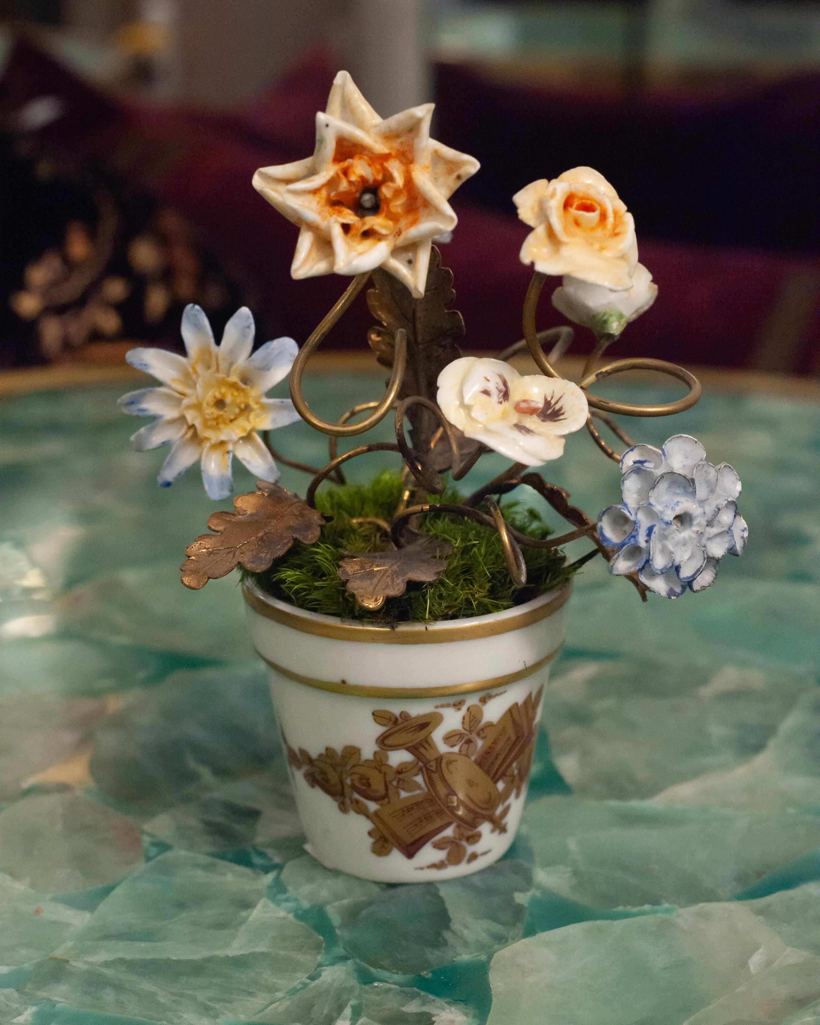 Uno studio di porcellana e poesia - Questa antica composizione francese cattura la bellezza fugace della natura in una forma duratura. Fiori di porcellana lavorati a mano, smaltati nei toni del blu e del pesca, poggiano su delicati steli e foglie di