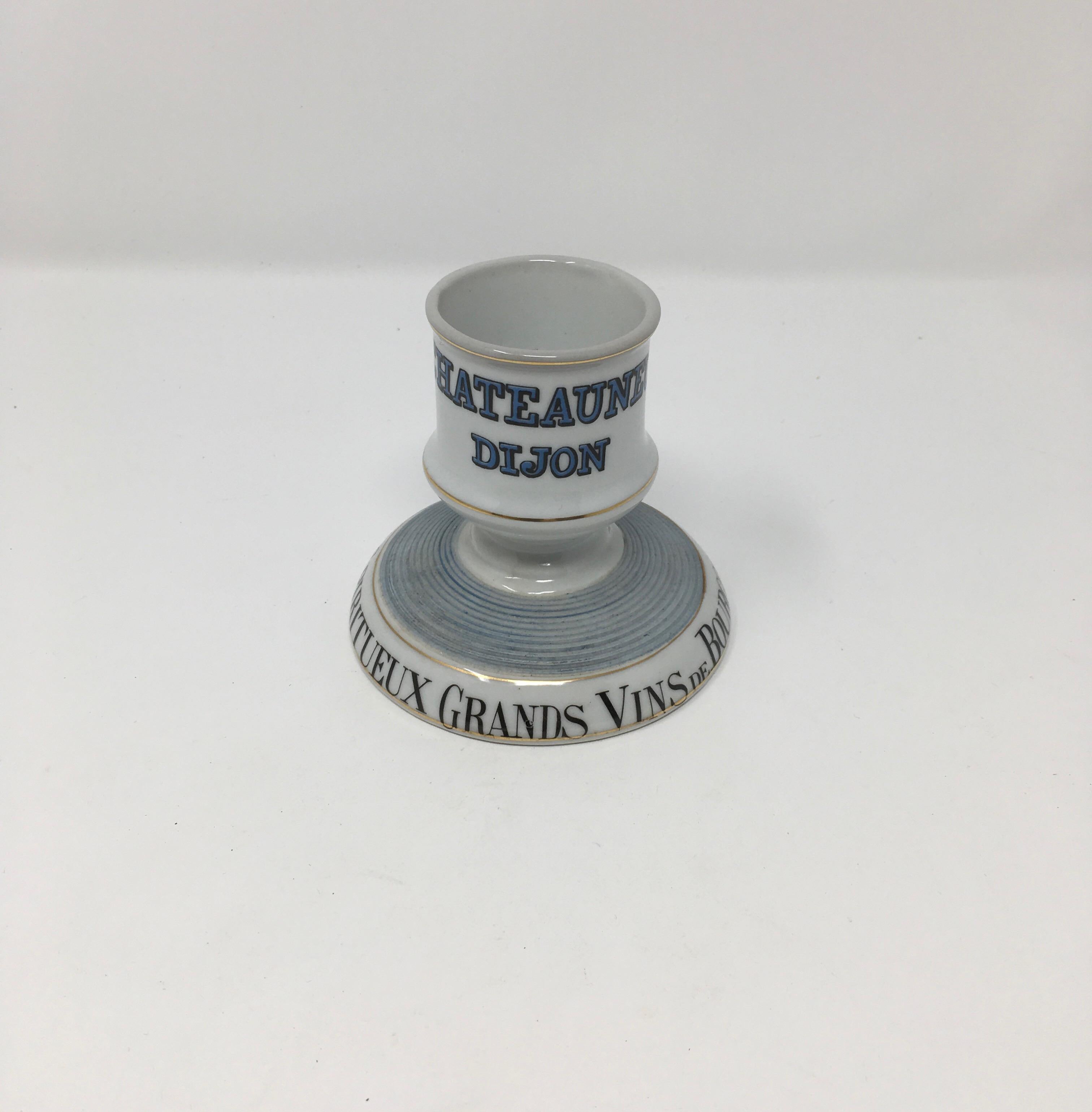 This French ceramic match striker and holder was made in the early 1900s. Match strikers were given to French bistros as a form of advertisement. This striker is made of white porcelain with decorative black lettering around the base and black