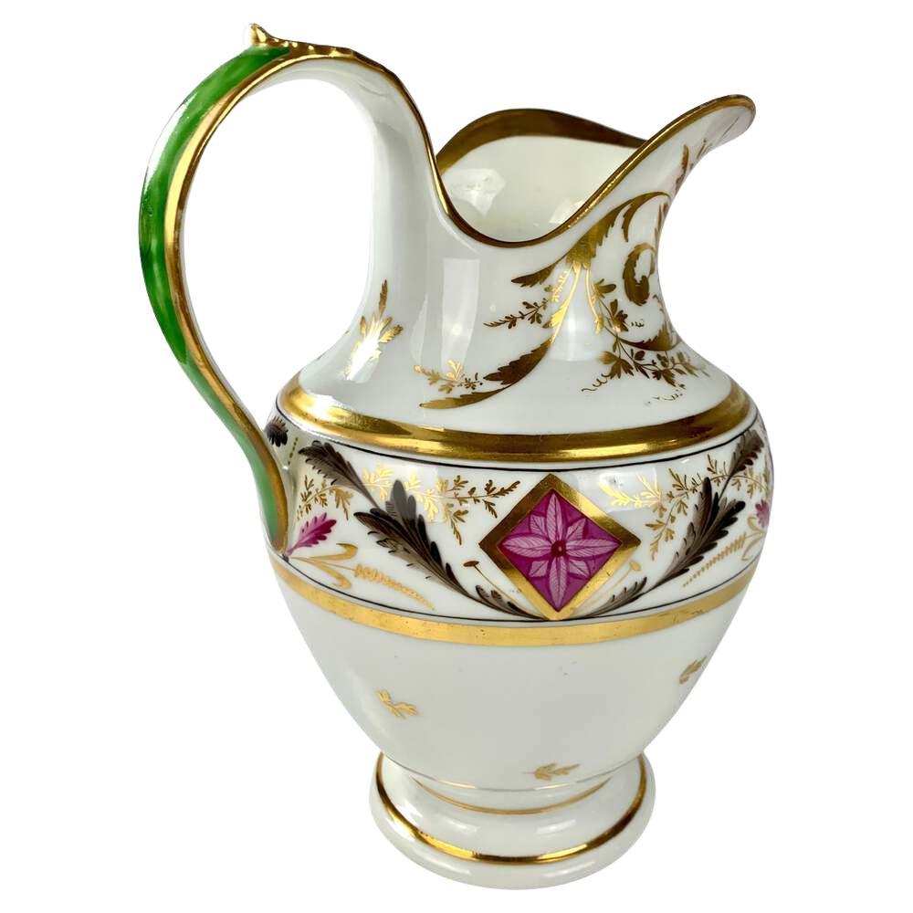 Made in the Napoleonic period, this exquisite French porcelain pitcher was hand-painted
in the Empire style. 
It boasts classical and rococo influences, with a bold purple square outlined in gold and elegant swags of acanthus* leaves, symbolizing