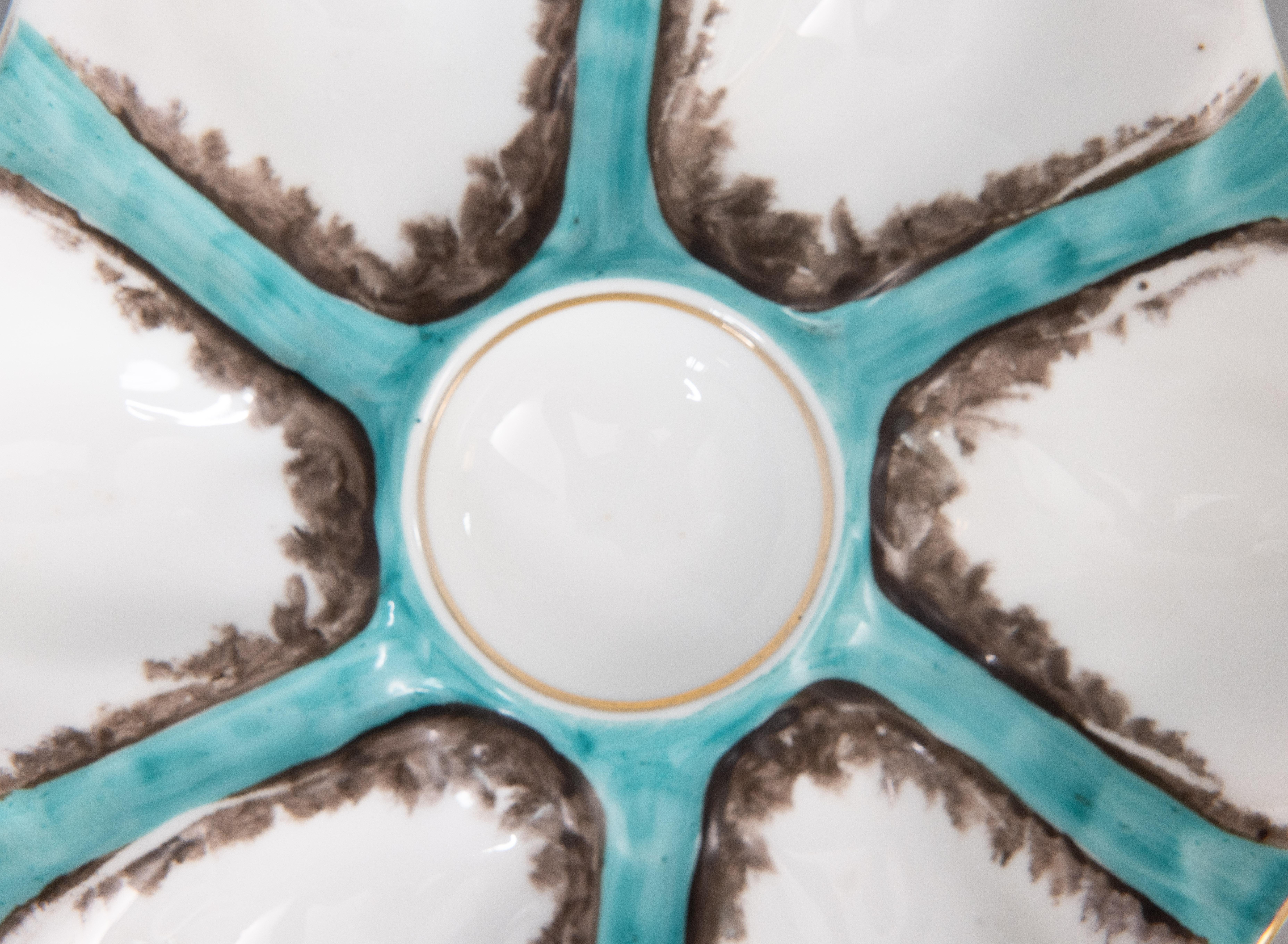A gorgeous antique French porcelain oyster plate attributed to Limoges, circa 1900. This fine quality oyster plate has six wells and is hand painted in a beautiful blue green teal / turquoise color with gilt details. It displays beautifully and