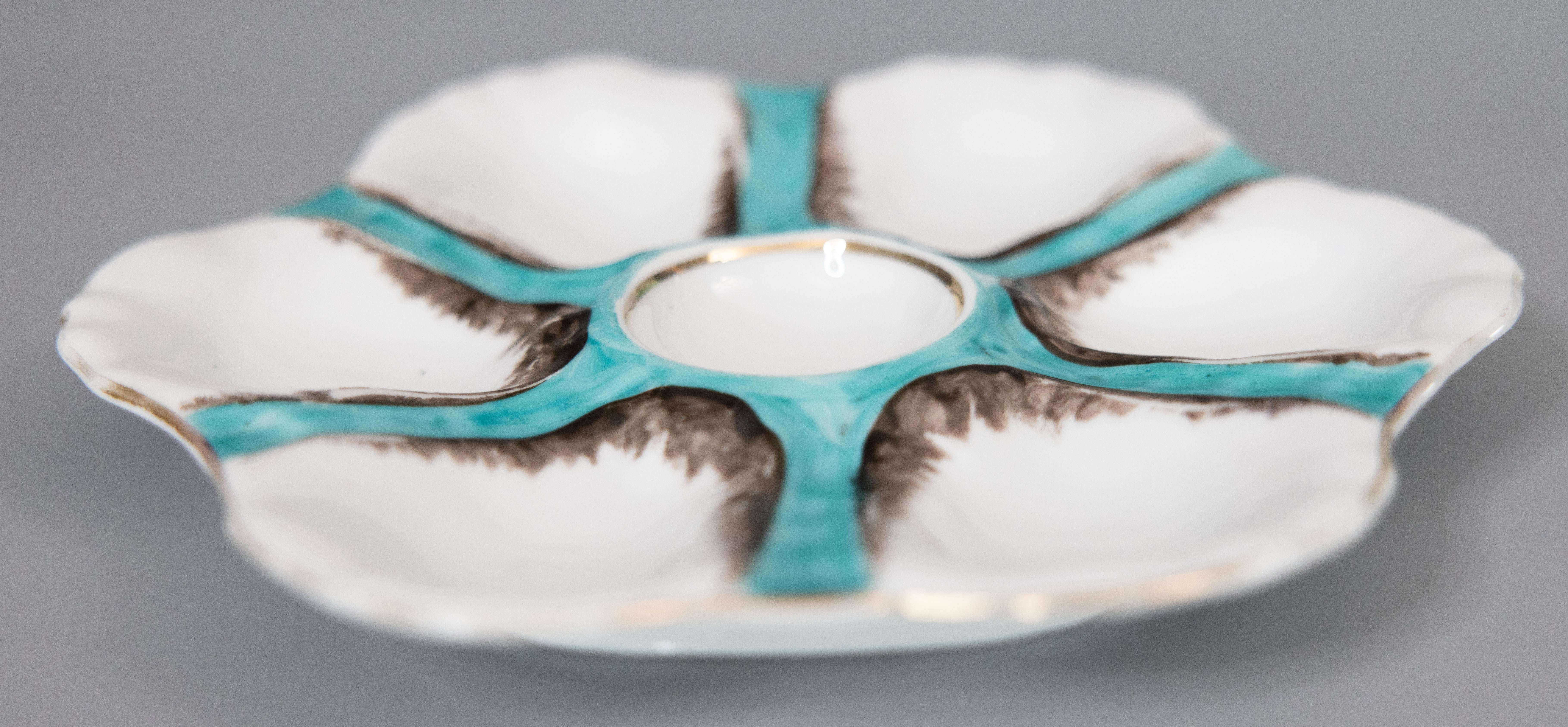 A gorgeous antique French porcelain oyster plate attributed to Limoges, circa 1900. This fine quality oyster plate has six wells and is hand painted in a beautiful blue green teal / turquoise color with gilt details. It displays beautifully and