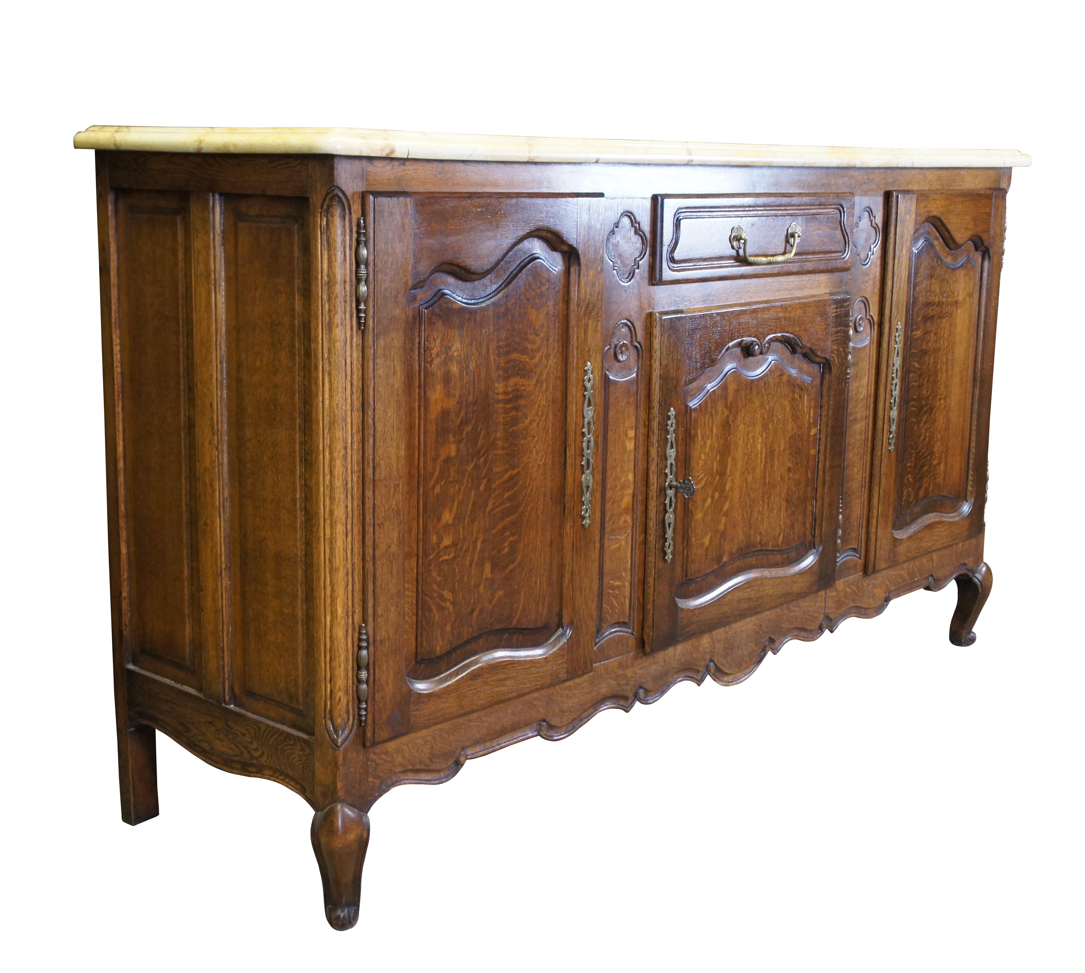 Antique Belgian made oak sideboard. Features French Provincial styling with quartersawn (tiger) oak panelling and yellow / off-white faux marble top. Includes 3 lockable cabinets, central drawer for flatware. scalloped and scrolled accents. The