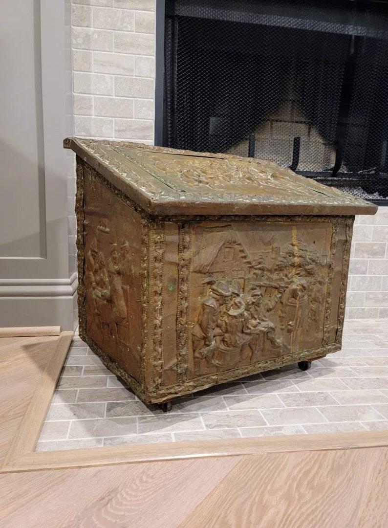 Patina perfection! A fabulous French brass repousse coal box from the late 19th to early 20th century. 

Born in France, circa 1900, featuring heavily patinated brass-clad solid wood construction, having a slanted hinged lid top over chest form