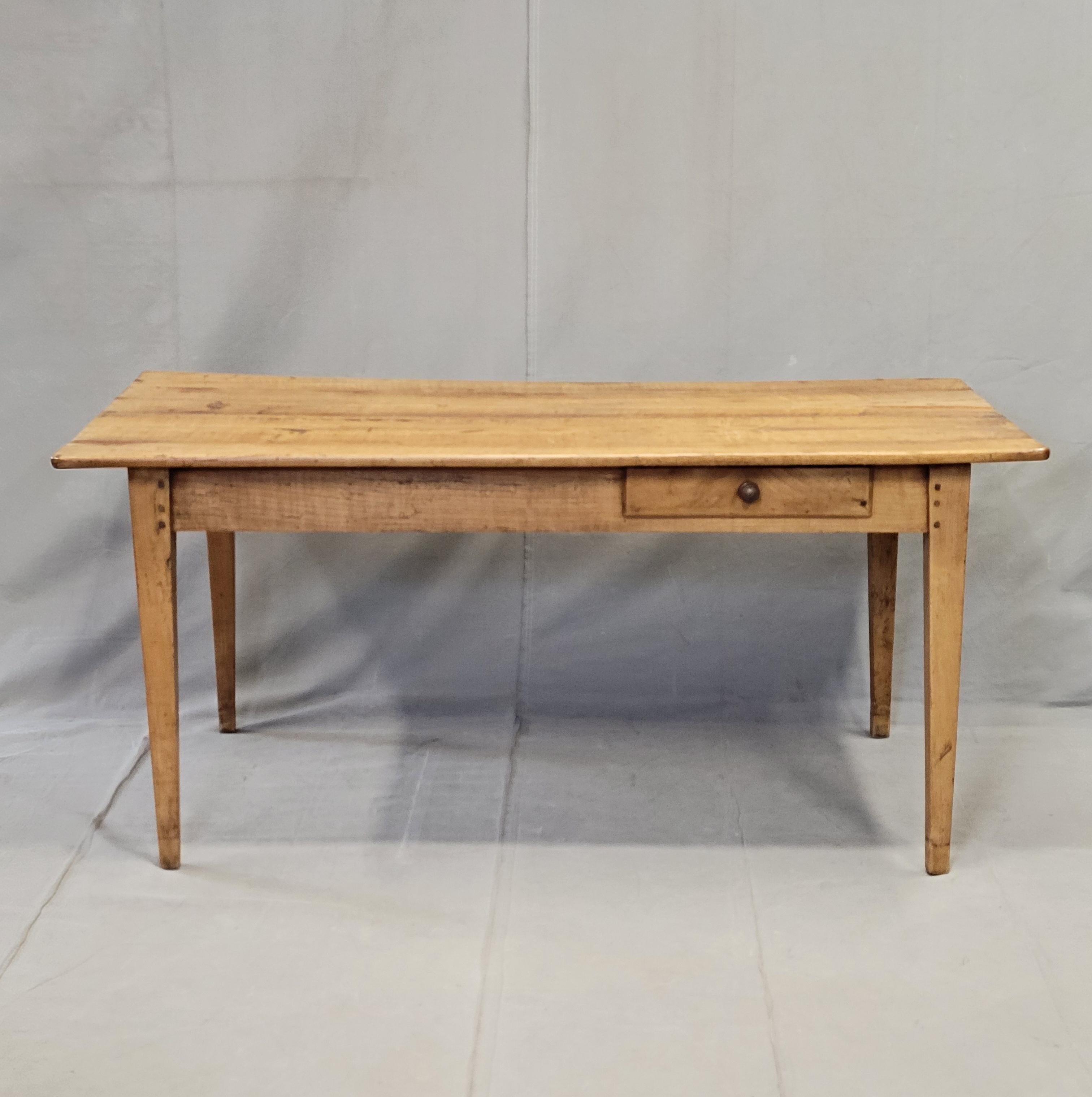 Magnifique table de ferme rustique en merisier massif de style provincial français datant du milieu ou de la fin des années 1800, avec une planche à pain intégrée et deux tiroirs de rangement. L'âge de cette table est évident dans les imperfections