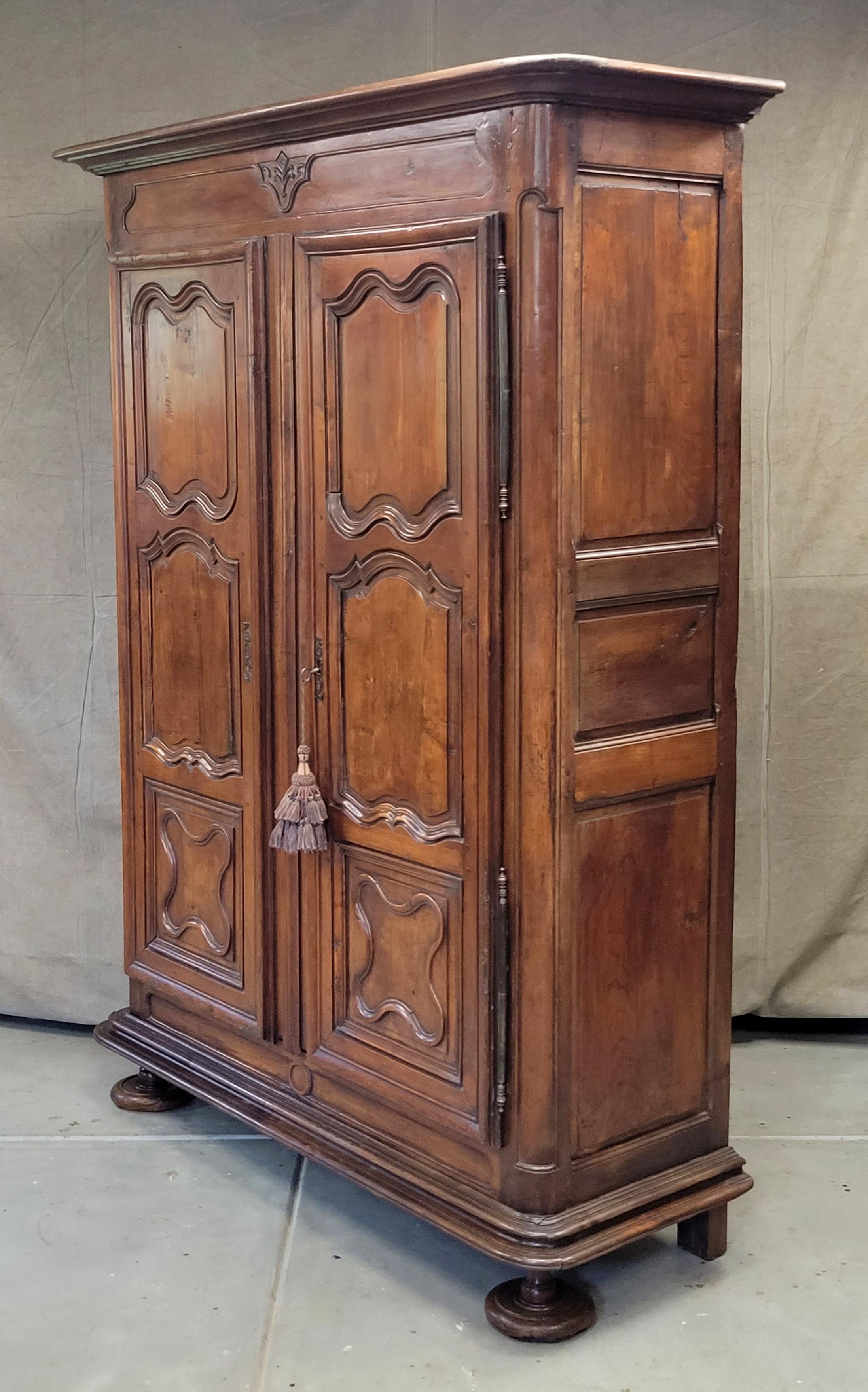 A gorgeous, handcrafted, stately antique late 18th century or early 19th century French armoire with three shelves. Made of mixed hardwoods (cherry, elm, chestnut), as French provincial pieces from this era were. Original waxed finish that just