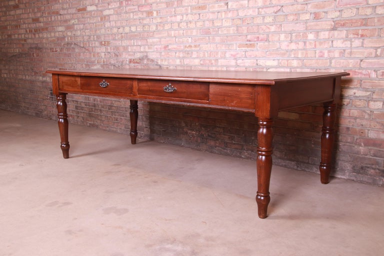 A gorgeous antique solid elm harvest dining table with two drawers

France, Circa 1900

Solid elm with turned legs, two drawers, and original hardware.

Measures: 90