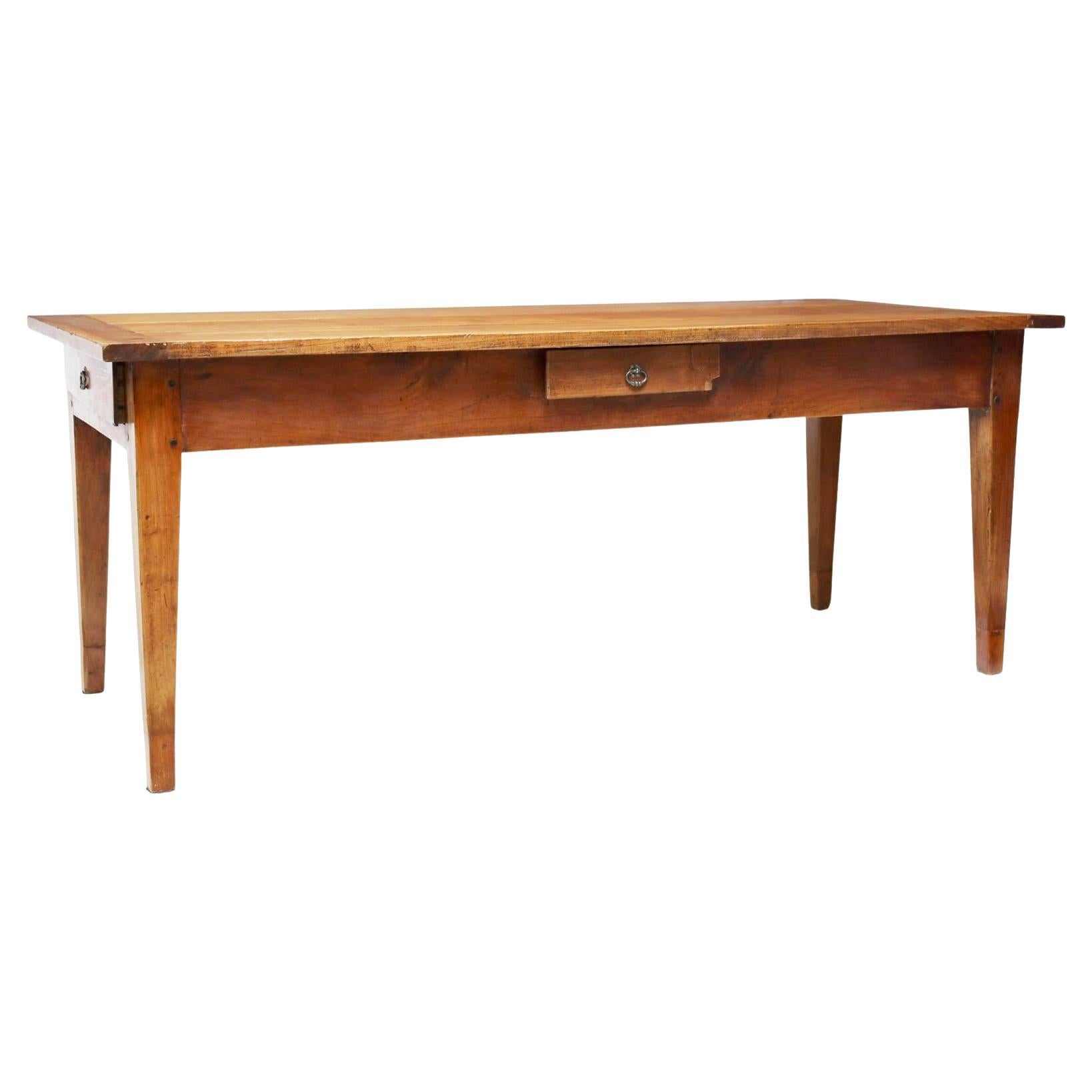 French Provincial fruitwood farmhouse table, early 20th c., having rectangular plank top, over apron fitted with three drawers, rising on tapered legs. Gorgeous color and patina.
Note: one drawer with old repair and small loss at corner (see