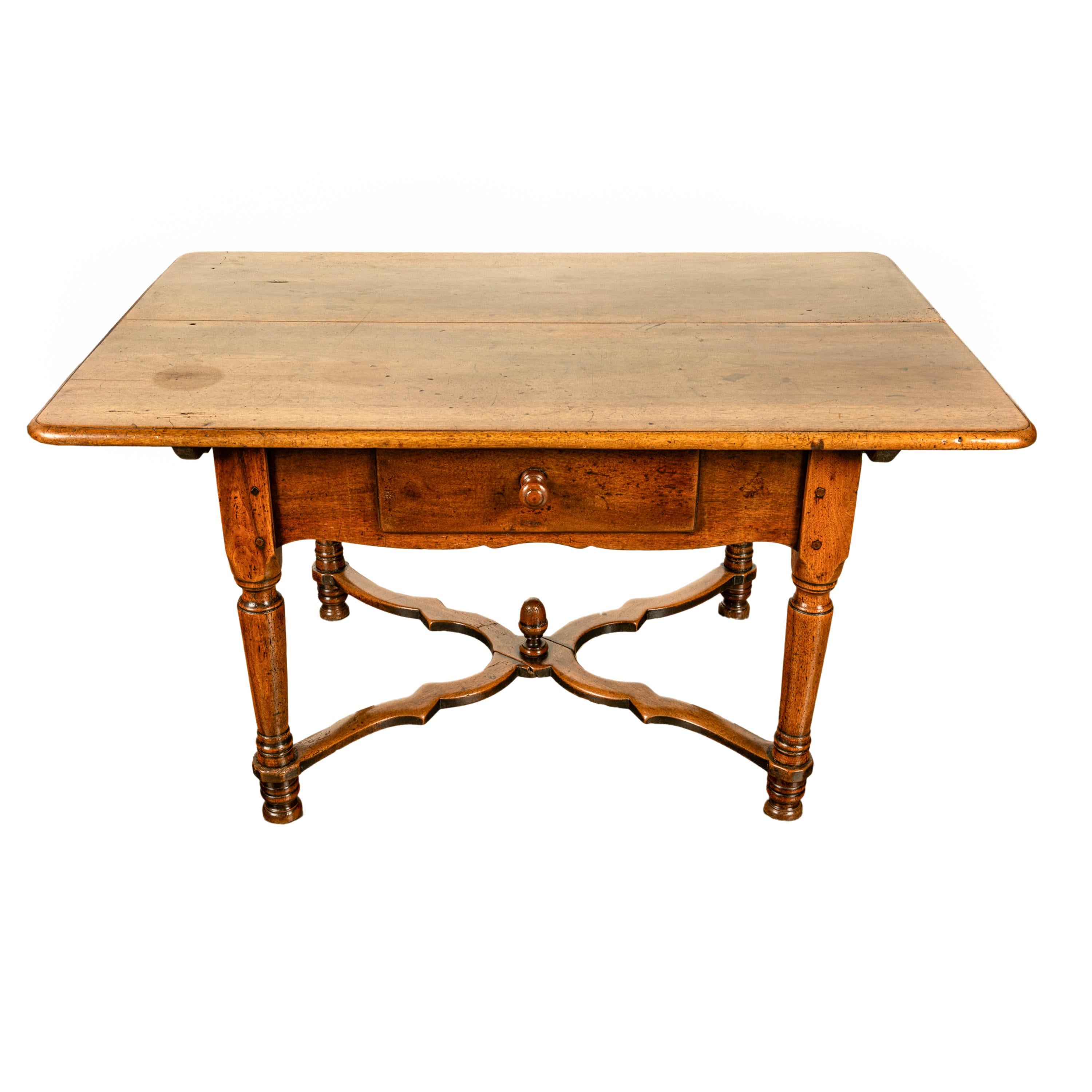 Une bonne table de salle à manger de style Louis XIII en noyer, circa 1820.
La table est dotée d'un plateau en surplomb et d'une base substantielle avec un seul tiroir profond à l'avant et une jupe façonnée sur les quatre côtés. 
La table est de