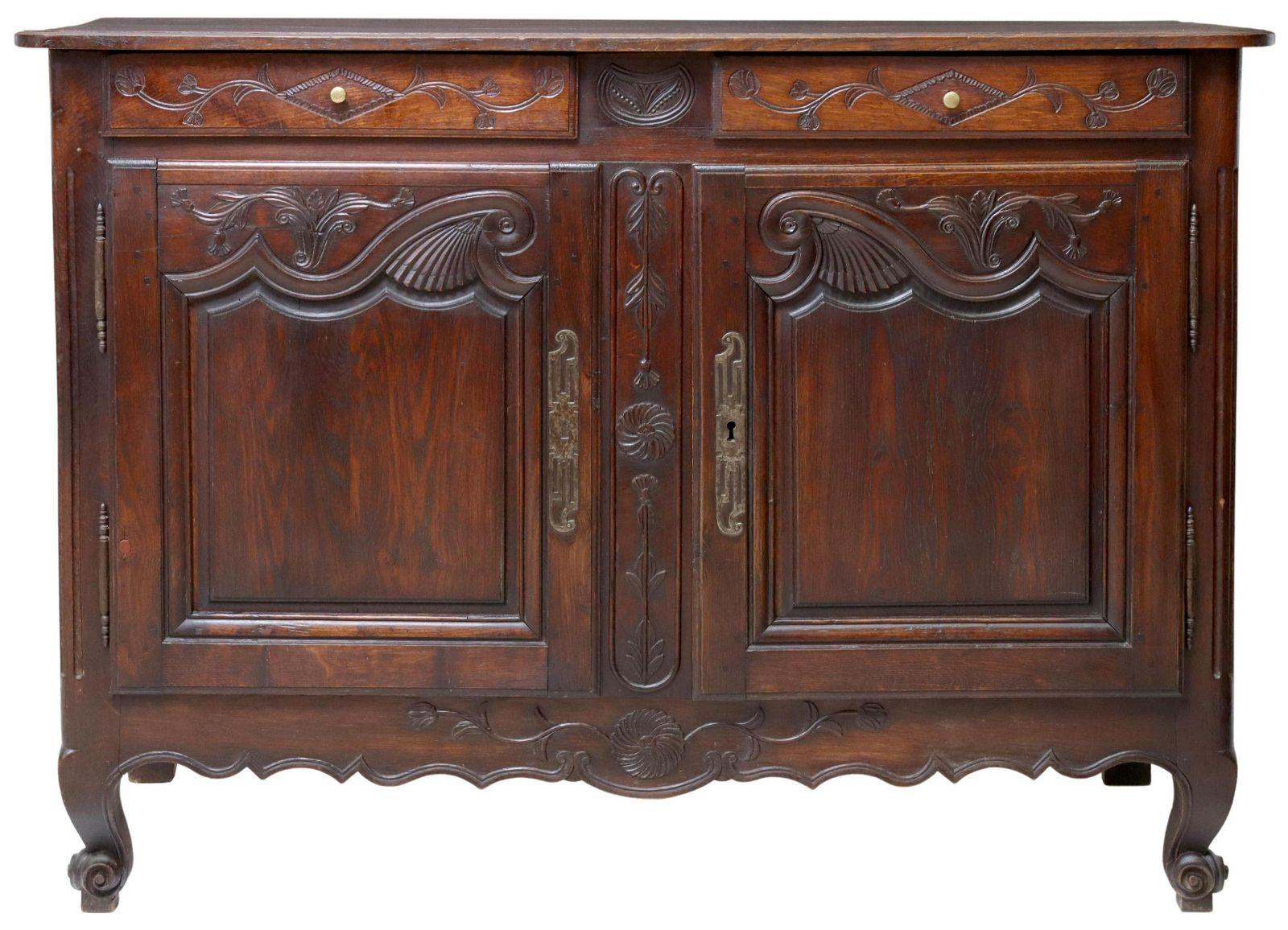 French Louis XV style oak sideboard, late 19th c., two drawers, over two cabinet doors, scalloped apron, rising on whorl feet. Detailed carving on each door panel.

Dimensions: approx 39