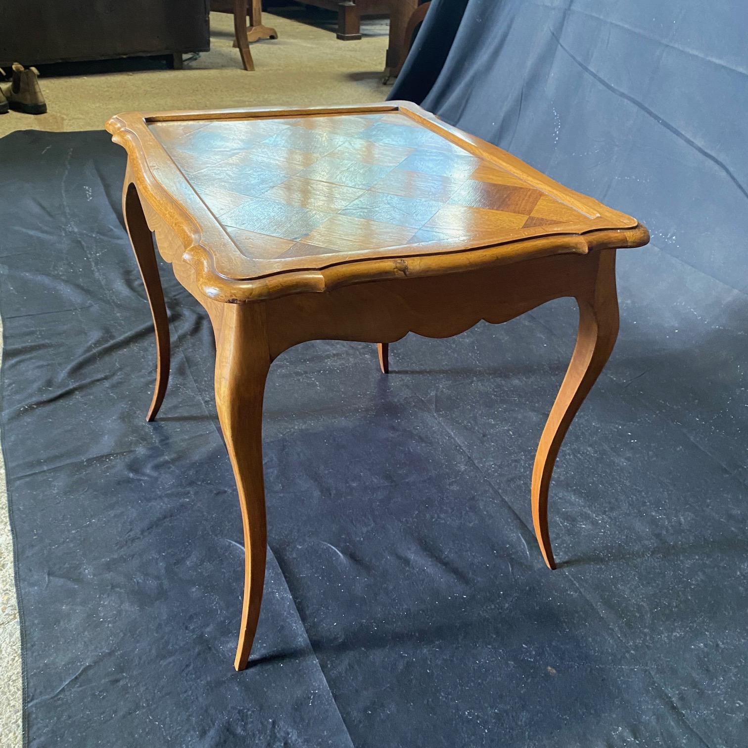 Antique French Tavolino Luigi XV in noce intagliato  bellissimo piano in parquet bordato.  Il design del parquet sul piano del tavolo è caratterizzato da bellissime venature e da un'ampia fascia con bordi smussati. Il grembiule presenta delicati