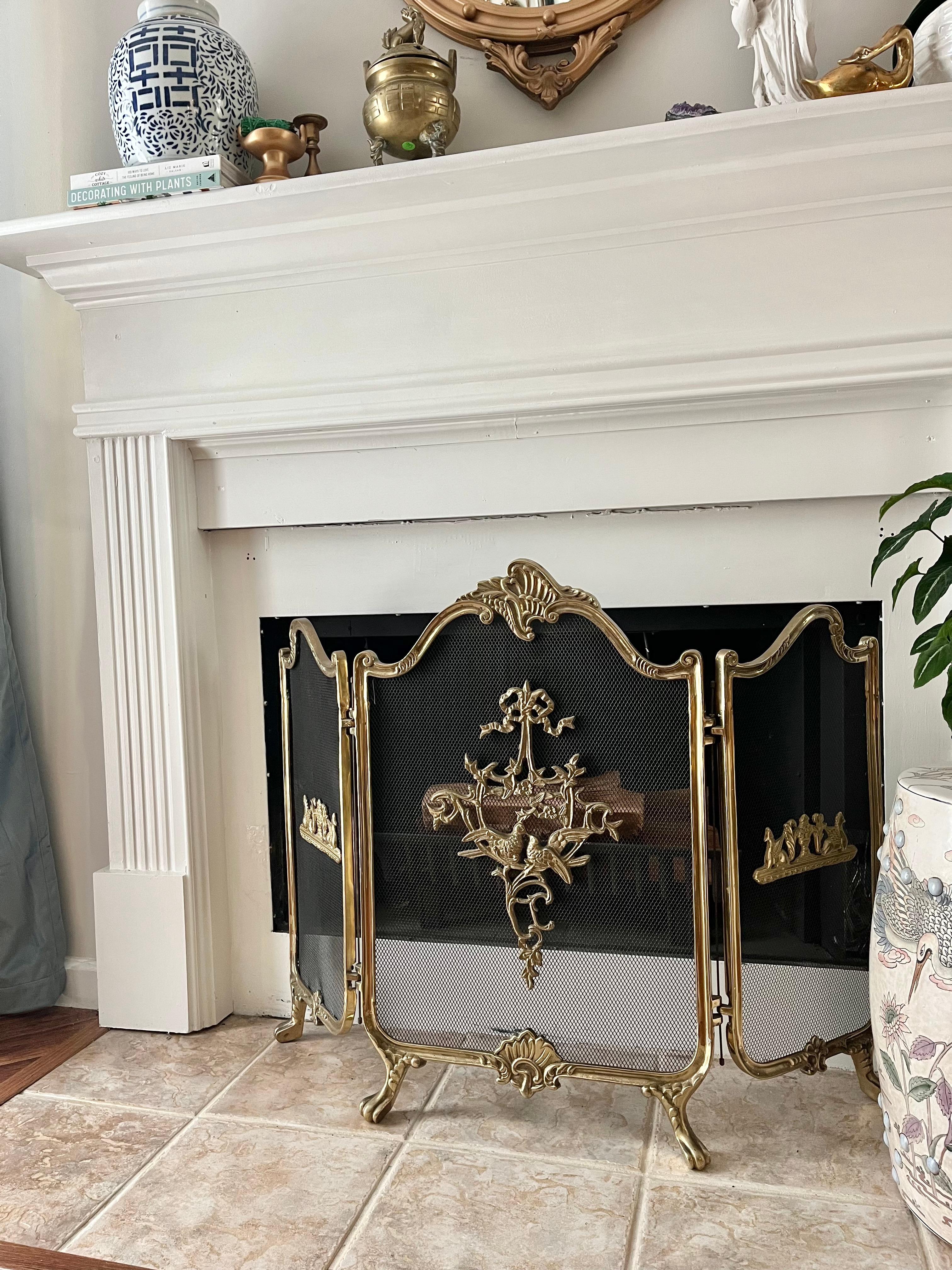Elevate your fireplace with our vintage French Provincial style three-section folding Fireplace Screen! Crafted from solid lacquered brass with paw feet, each panel intricately depicts birds and flowers intertwined with elegant ribbon designs,