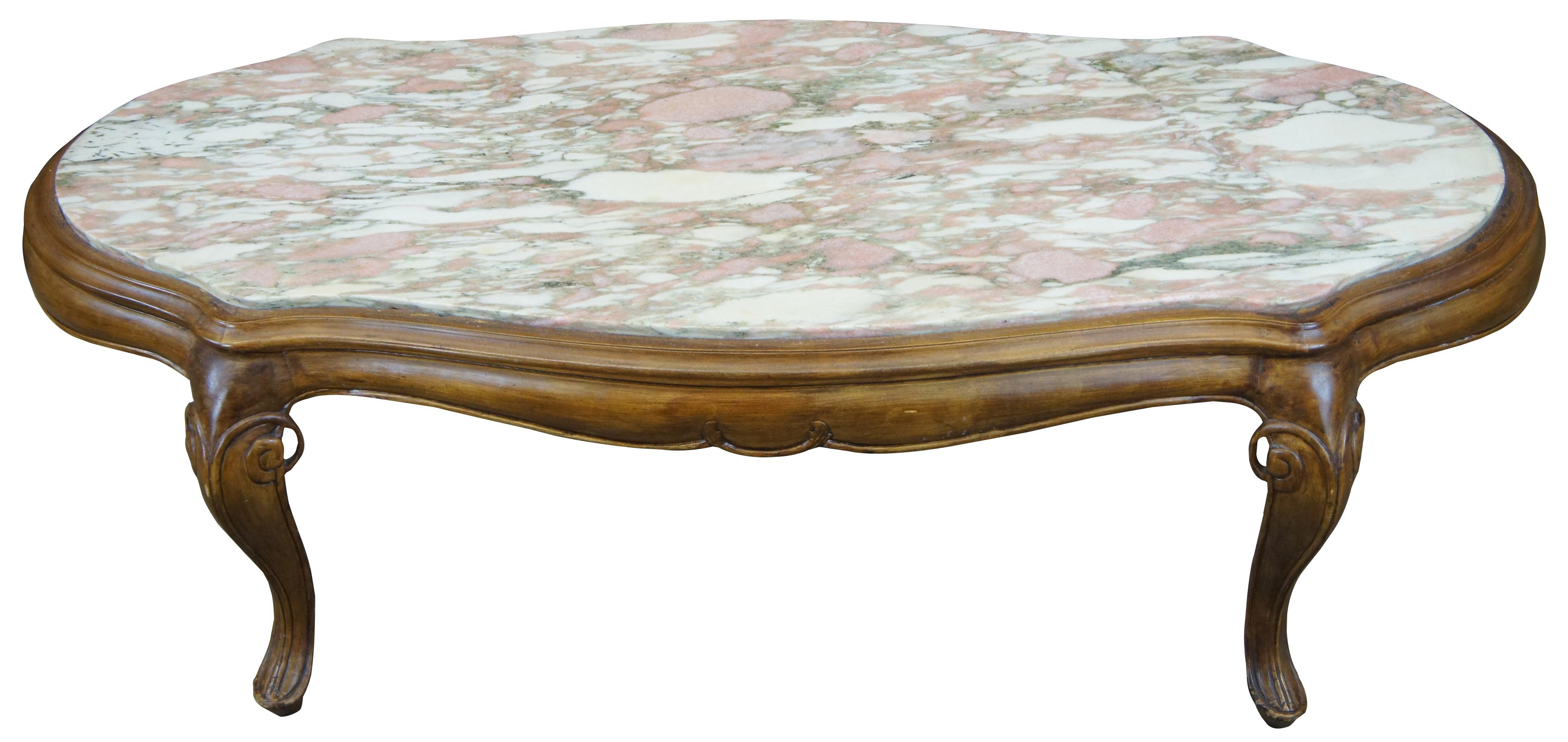 Antique French Provincial coffee table. Made of walnut and pink marble featuring oval serpentine form with scrolled and beveled accents.
 