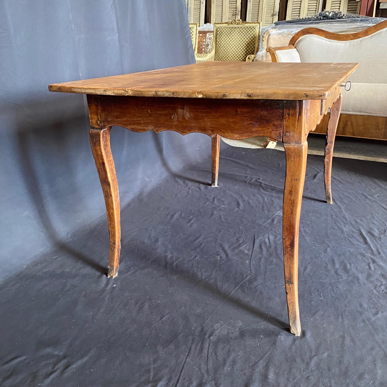 Antique French Provincial / Country / Farmhouse dining table, large side table or buffet or desk. Made of pine featuring a lovely French Louis XV country primitive design with rectangular form, lovely patina, one dovetailed drawer, serpentine skirt