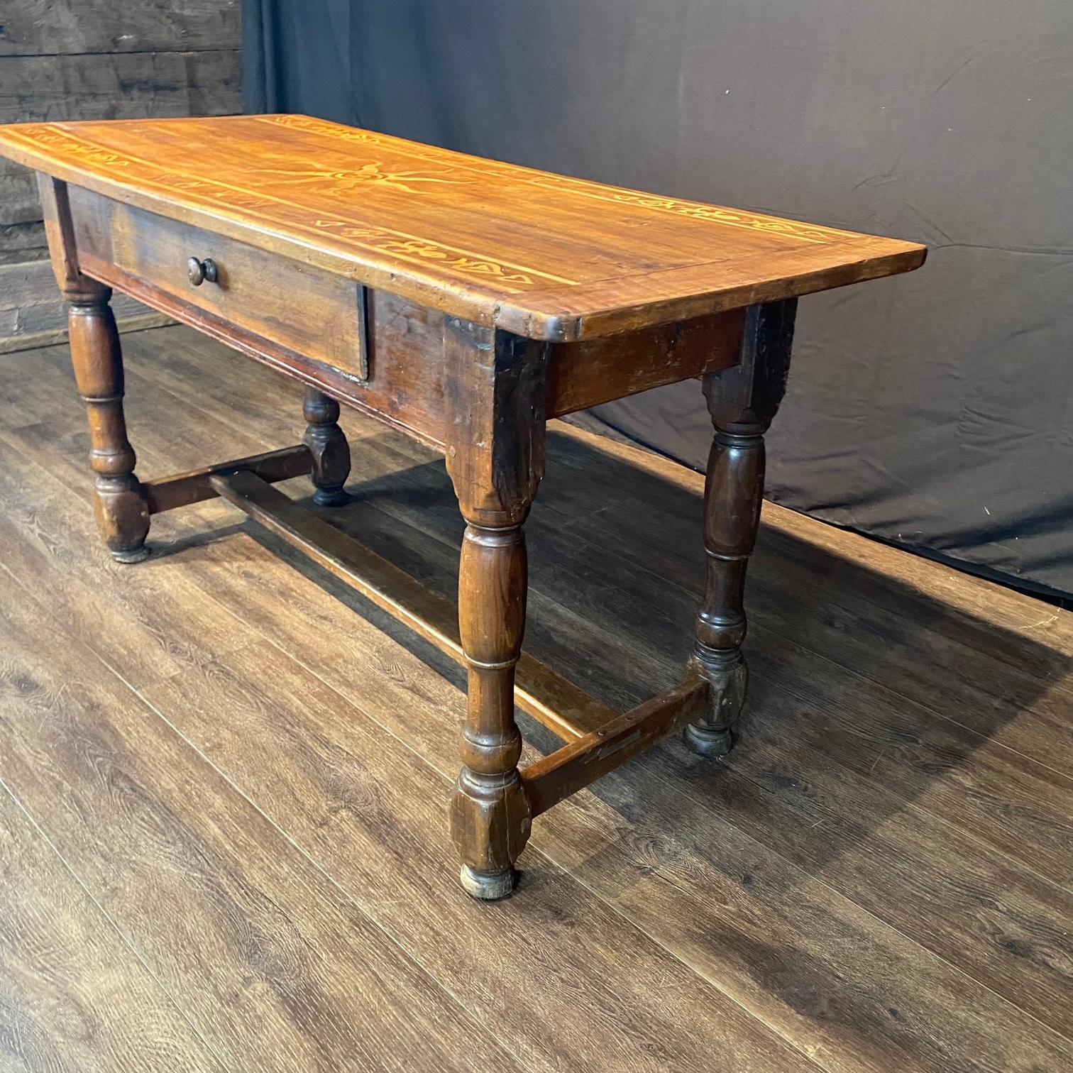 French side table with primitive inlay depicting a sun, figures and breadboard ends. A charming rustic versatile piece, sourced from Provence, France. Beautifully hand-crafted from solid walnut, it features a warm brown tone with rich, expressive