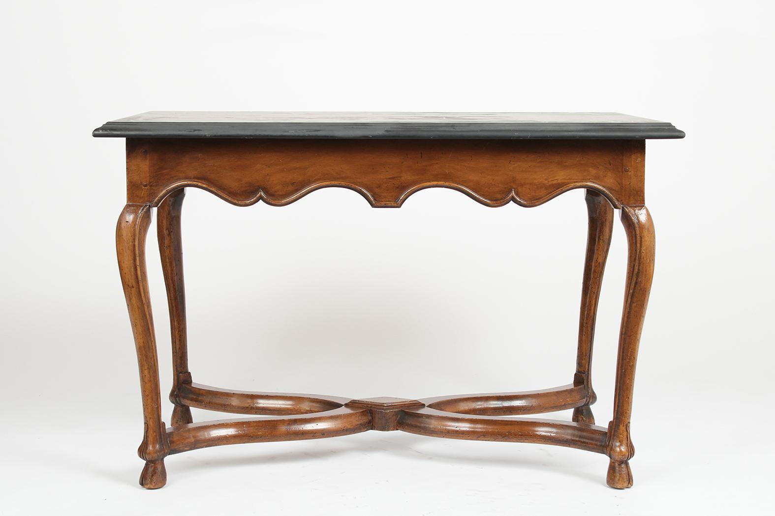 This 1880s French Provincial style marble side table is made out of walnut wood stained in its original color and has been waxed and polished giving it a patina finish. This antique piece features its original dark grey marble top with a beveled