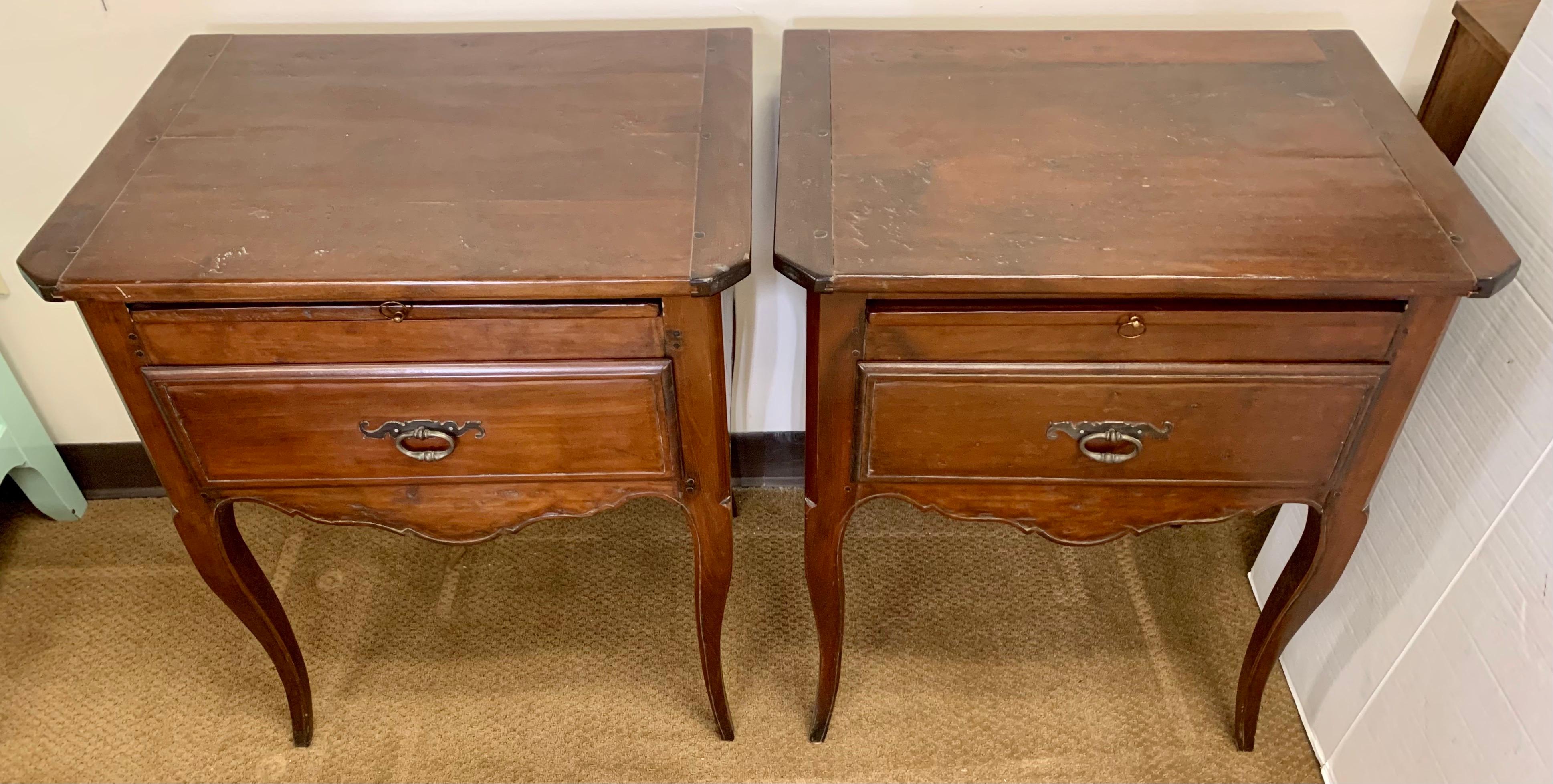Pair of French Provincial style walnut nightstands or end tables with a gorgeous aged patina only acquired through age and use. Each has one drawer and a pullout tea table.