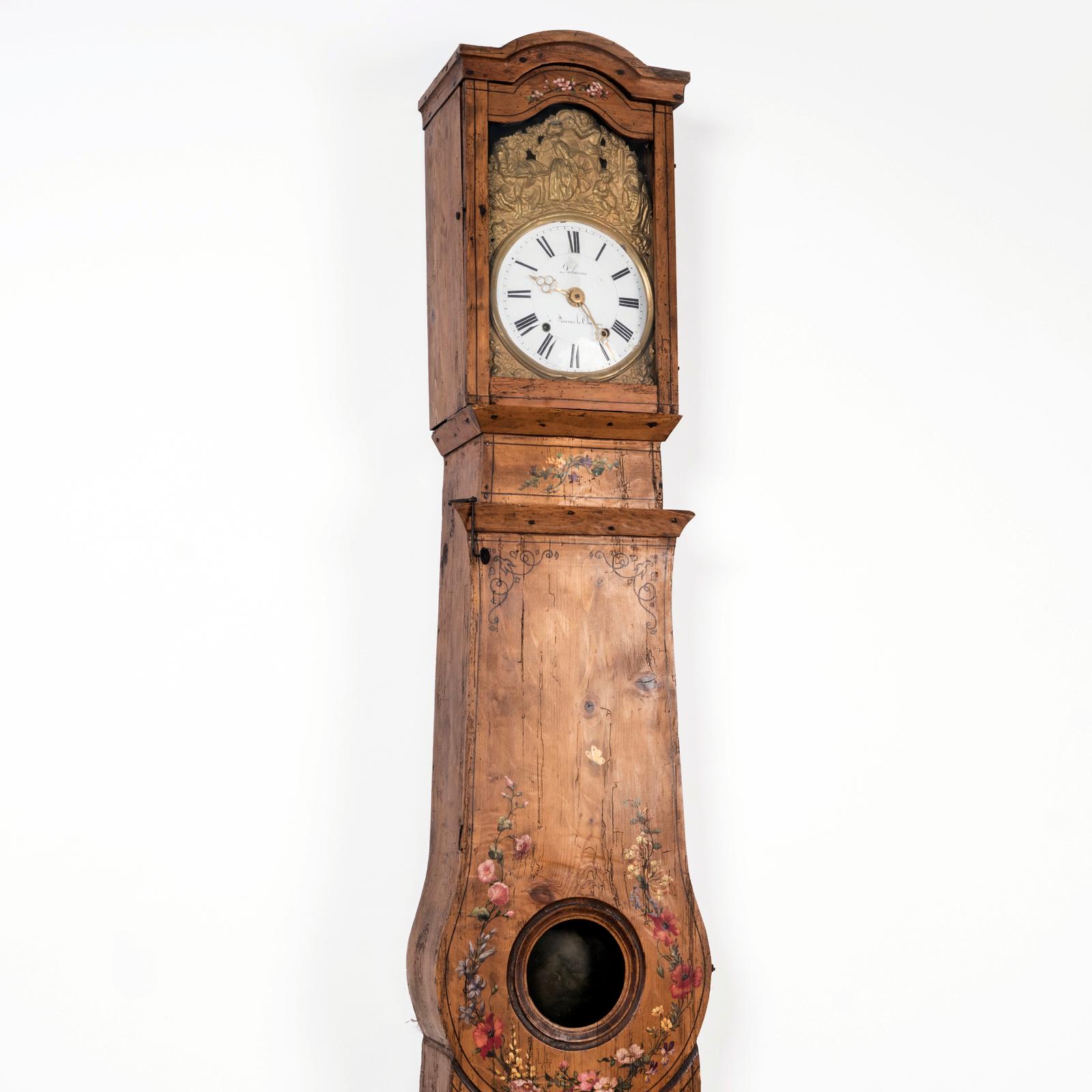 Very decorative and charming French tall case clock featuring a painted pine case adorned with floral decorations.

The porcelain clock dial bears the signature 