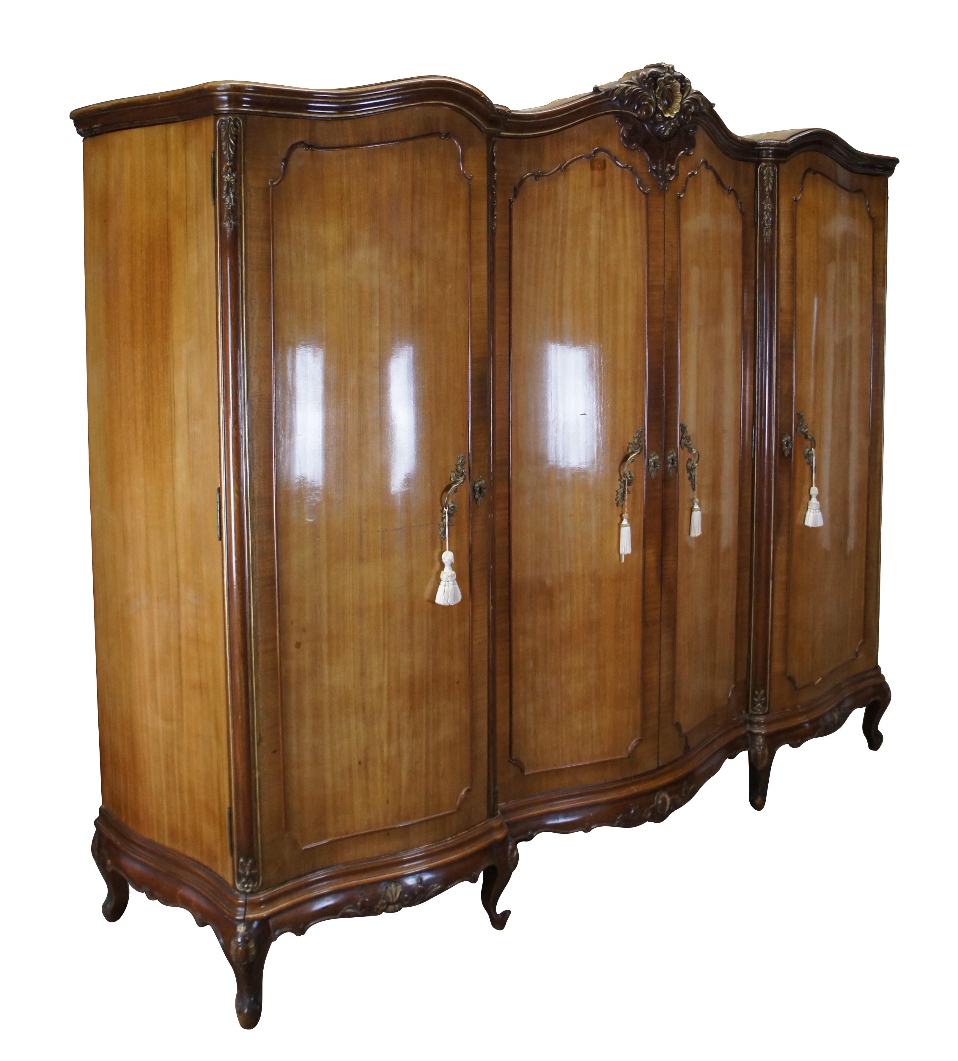 Antique French Provincial knockdown armoire / triple wardrobe / closet.  Made of walnut featuring serpentine form with scrolled acanthus design and three storage closets.  The central wardrobe has two doors that are lined with full length dressing