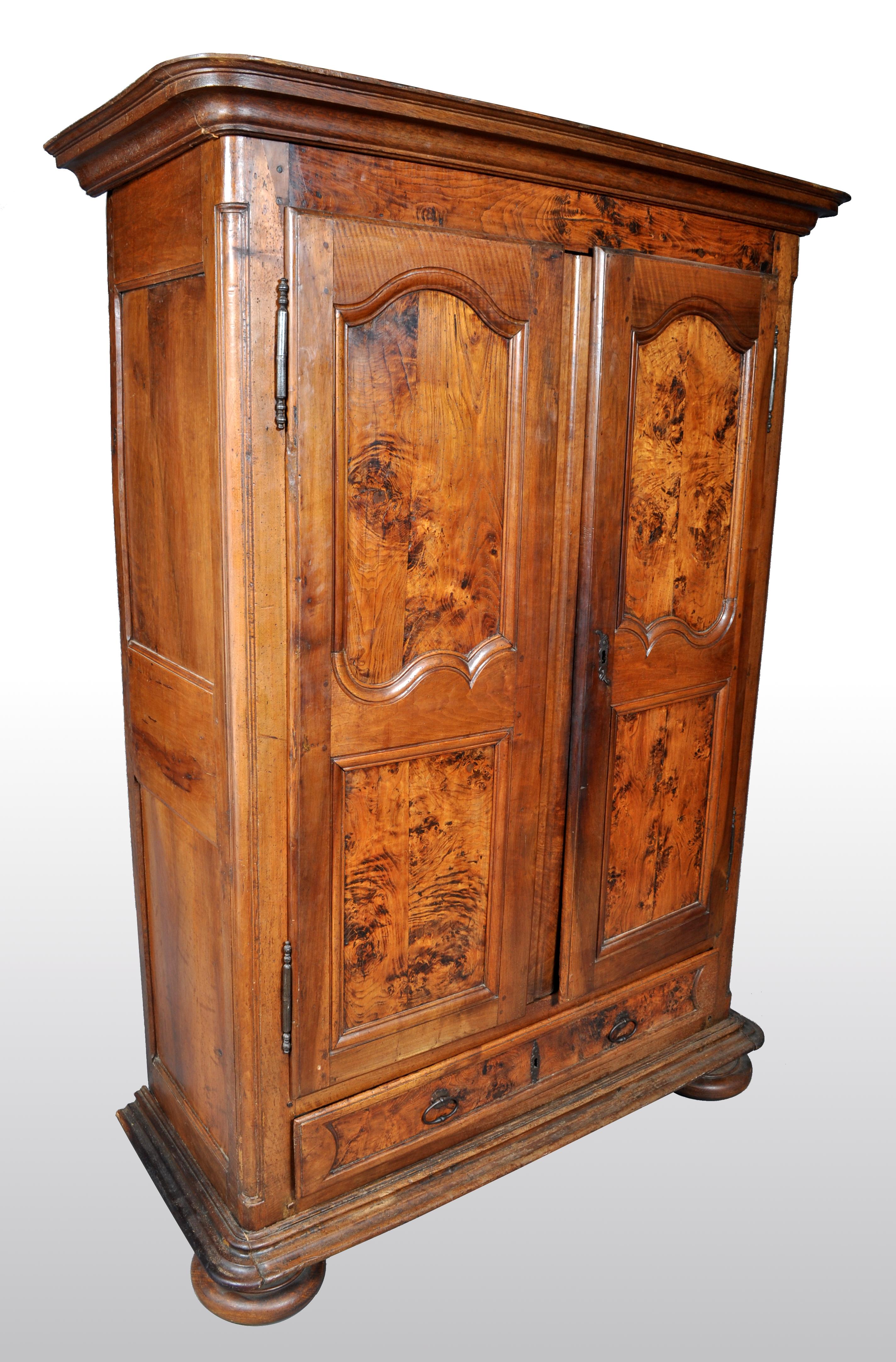 Antique French Provincial finely figured walnut wedding armoire, circa 1750. The armoire having a removable stepped cornice with a pair of shaped fielded panel doors below, having the original iron hinges and lock. To the base is a single drawer,