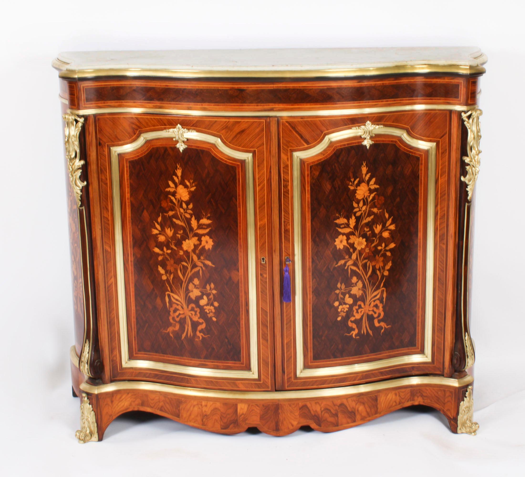 This is a superb and imposing antique French serpentine ormolu mounted, purple heart, walnut, marquetry and  marble topped side cabinet, C 1880 in date.

The entire piece highlights the unique and truly exceptional pattern of the floral marquetry
