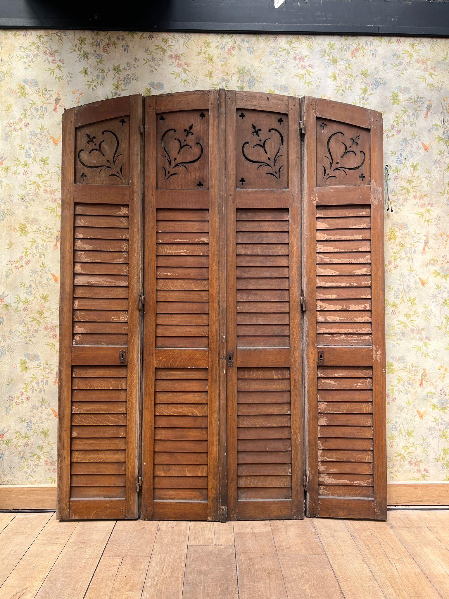 Dieser schöne antike Quadriptychon-Fensterladen ist ein seltener Fund aus Frankreich und stammt aus dem frühen 20. Jahrhundert (um 1900). Das aus Massivholz gefertigte Möbelstück verfügt über vier Lamellen mit eleganten, durchbrochenen Herz- und