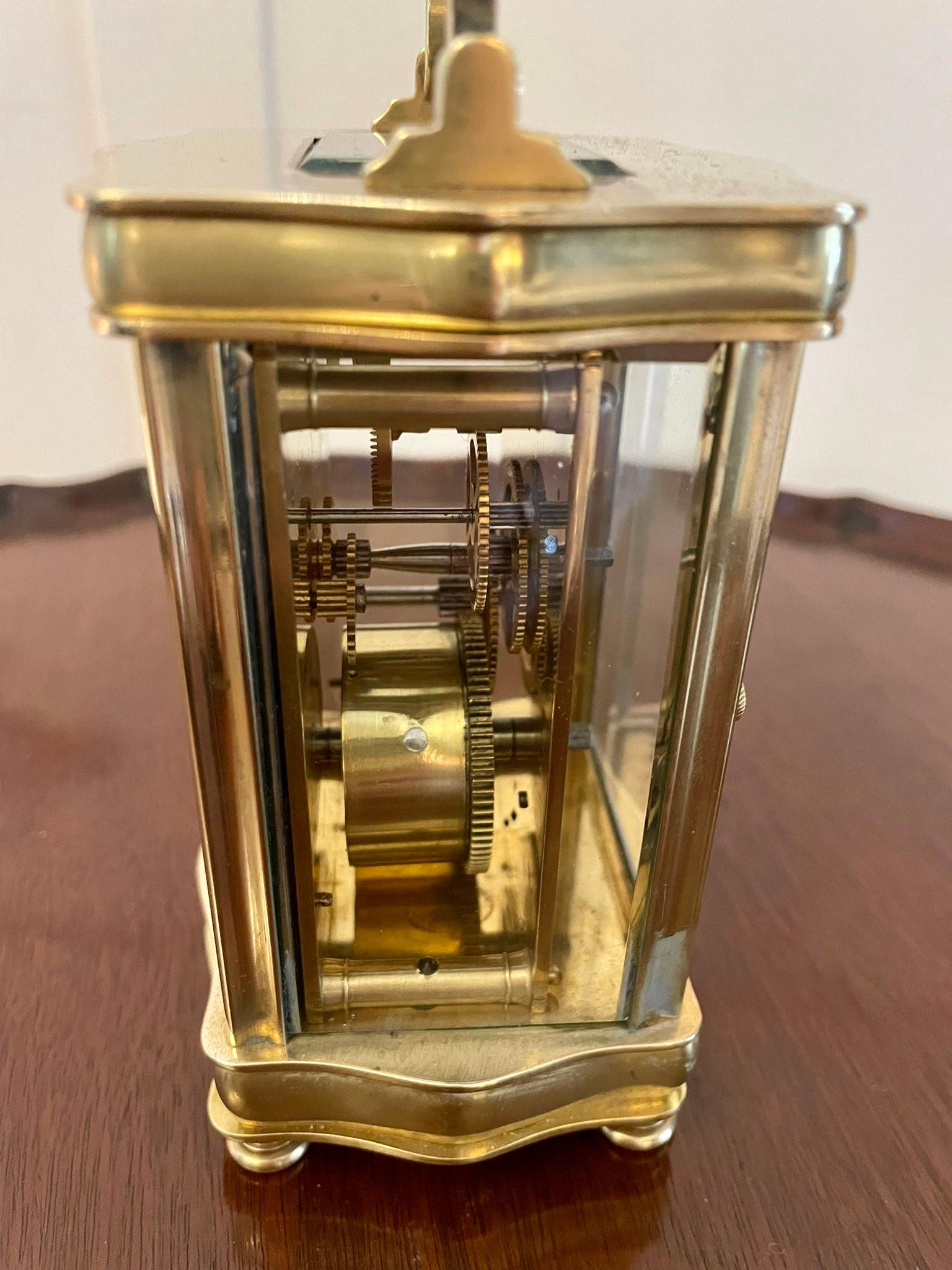 Antique French quality brass carriage clock having a quality brass serpentine shaped case with bevelled glass panels and door, shaped carrying handle to the top, enamel dial with original hands and Roman numerals, eight day movement and original