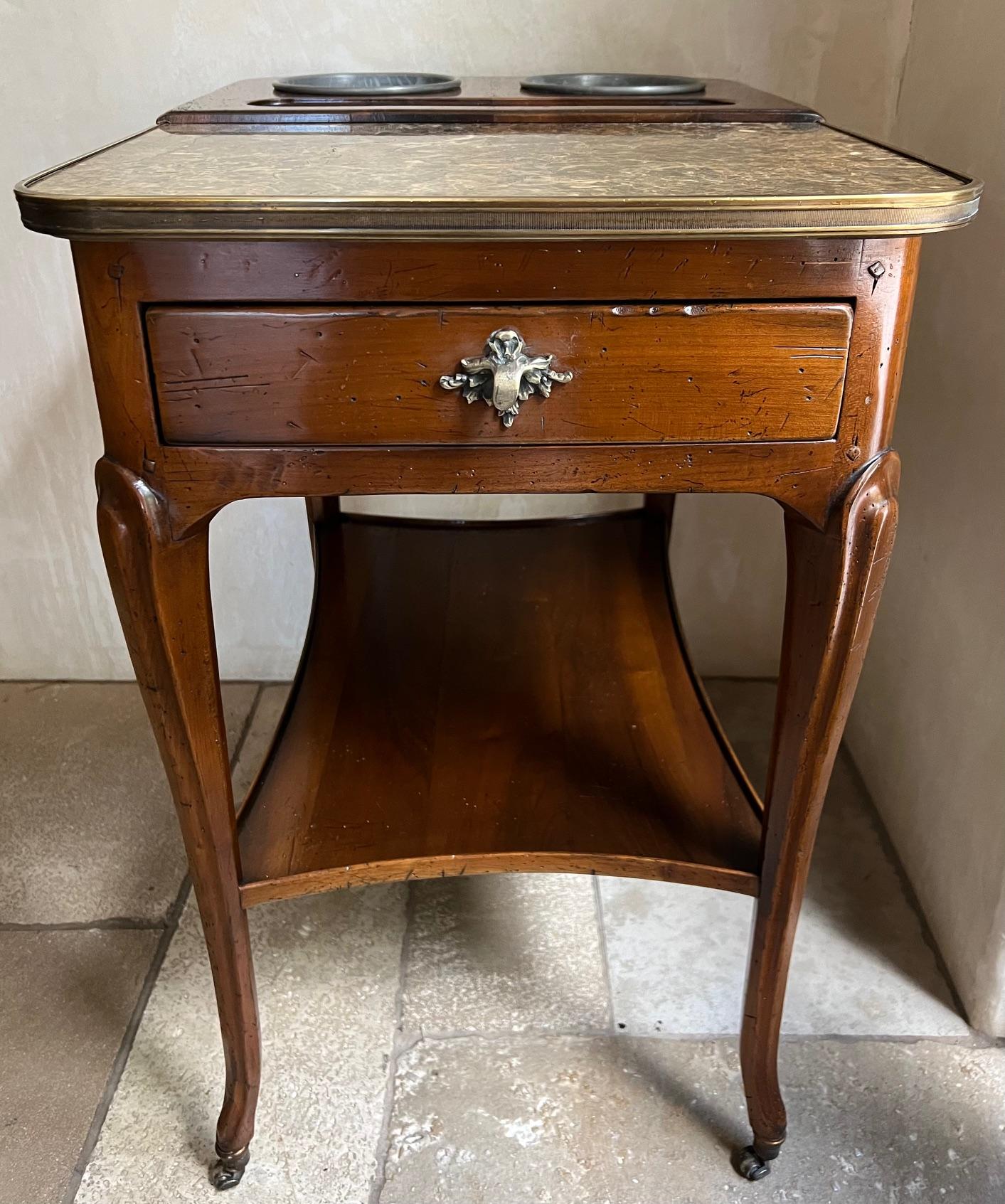 Antique rafraichissoir / champagne table made in France in the 1930's. The design, attributed to André Mailfert after a model by Joseph Canabas, is half marble trimmed in brass and half walnut with buckets inset. There is a lined drawer with a brass